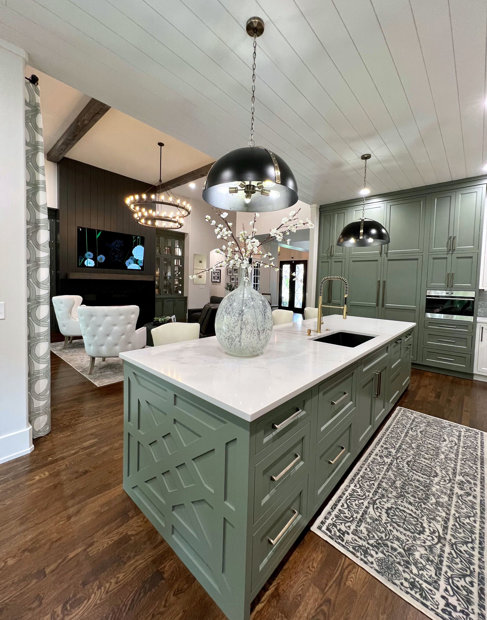A kitchen with green cabinets and white counter tops