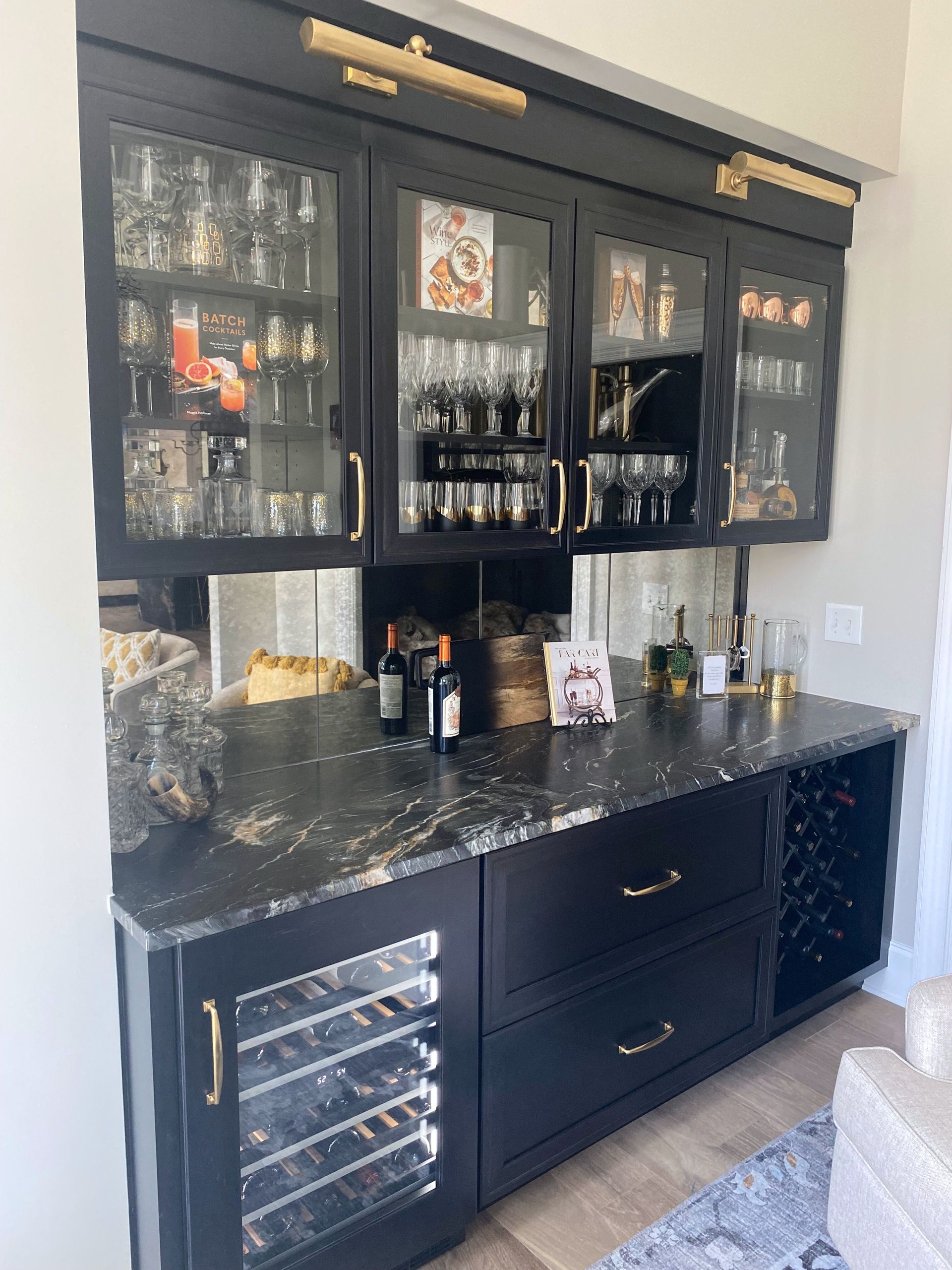 A kitchen with black cabinets and a wine cooler.