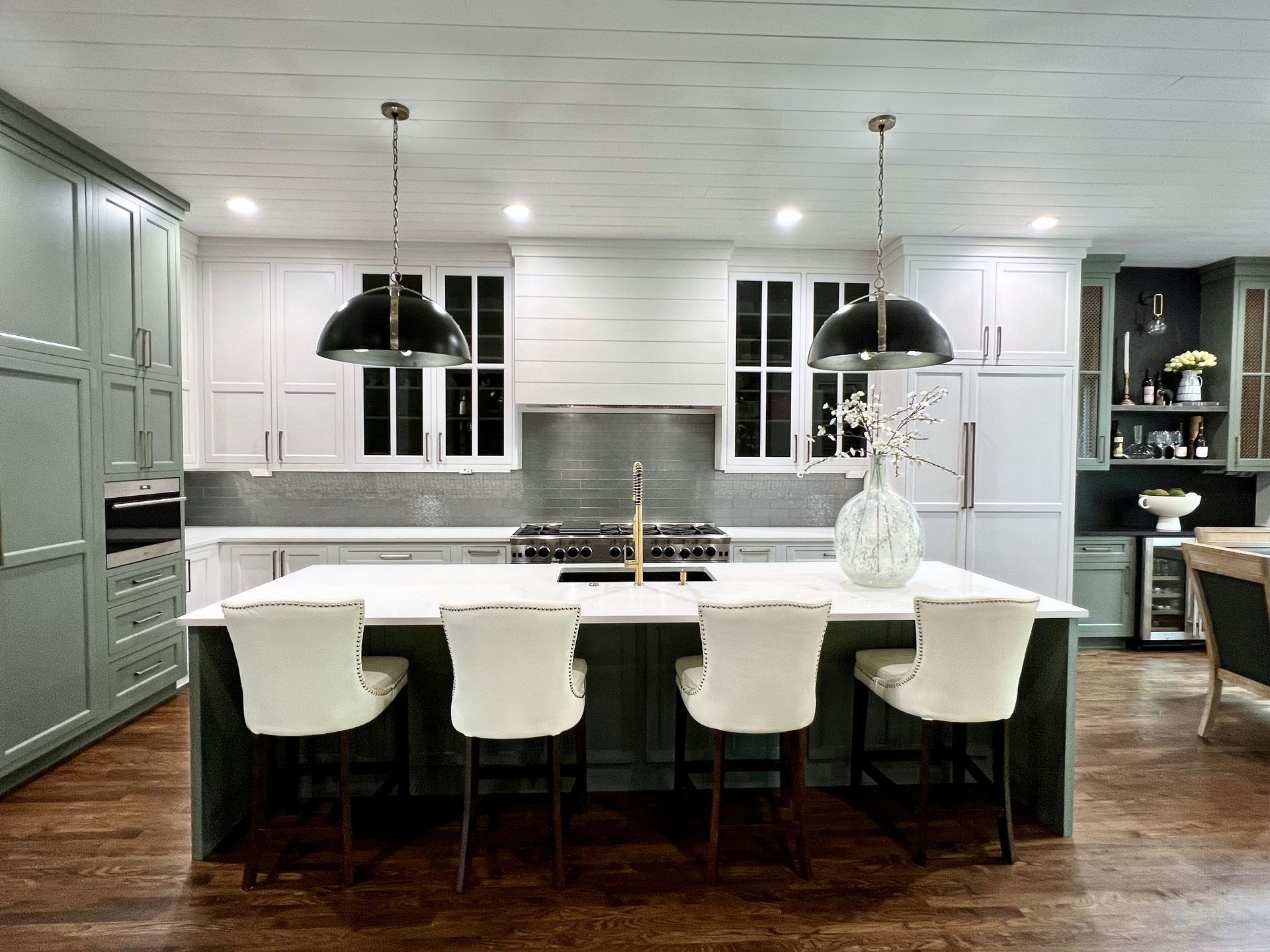 A kitchen with white cabinets and a large island in the middle.