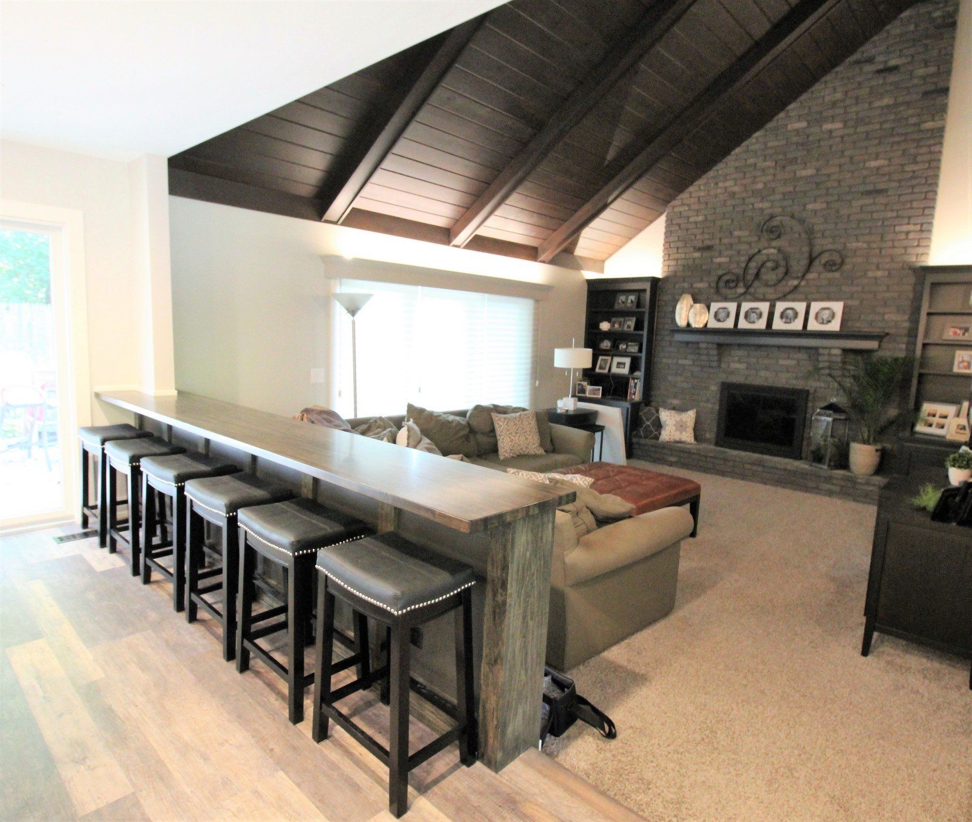 A living room with a fireplace and a long bar