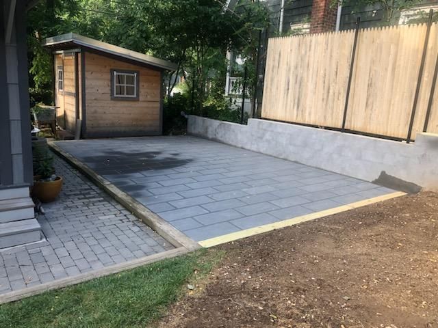 A large black house with a patio and chairs in front of it.