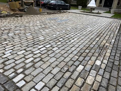 A close up of a cobblestone street with a diagonal pattern.