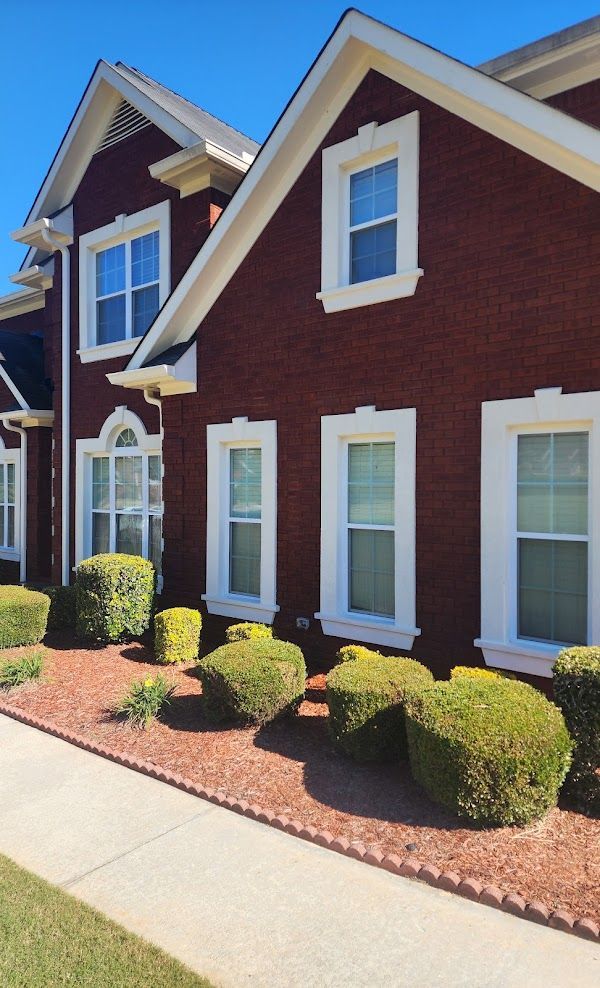 A red brick house with white trim and windows