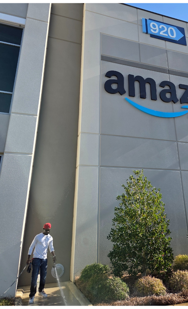 A man is standing in front of an amazon building