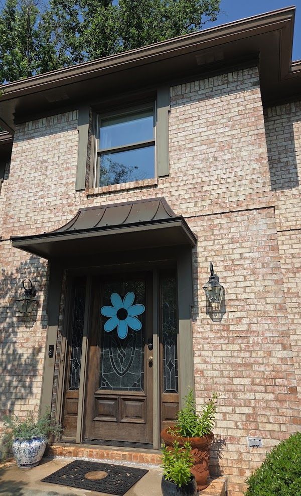 A brick house with a blue flower on the front door
