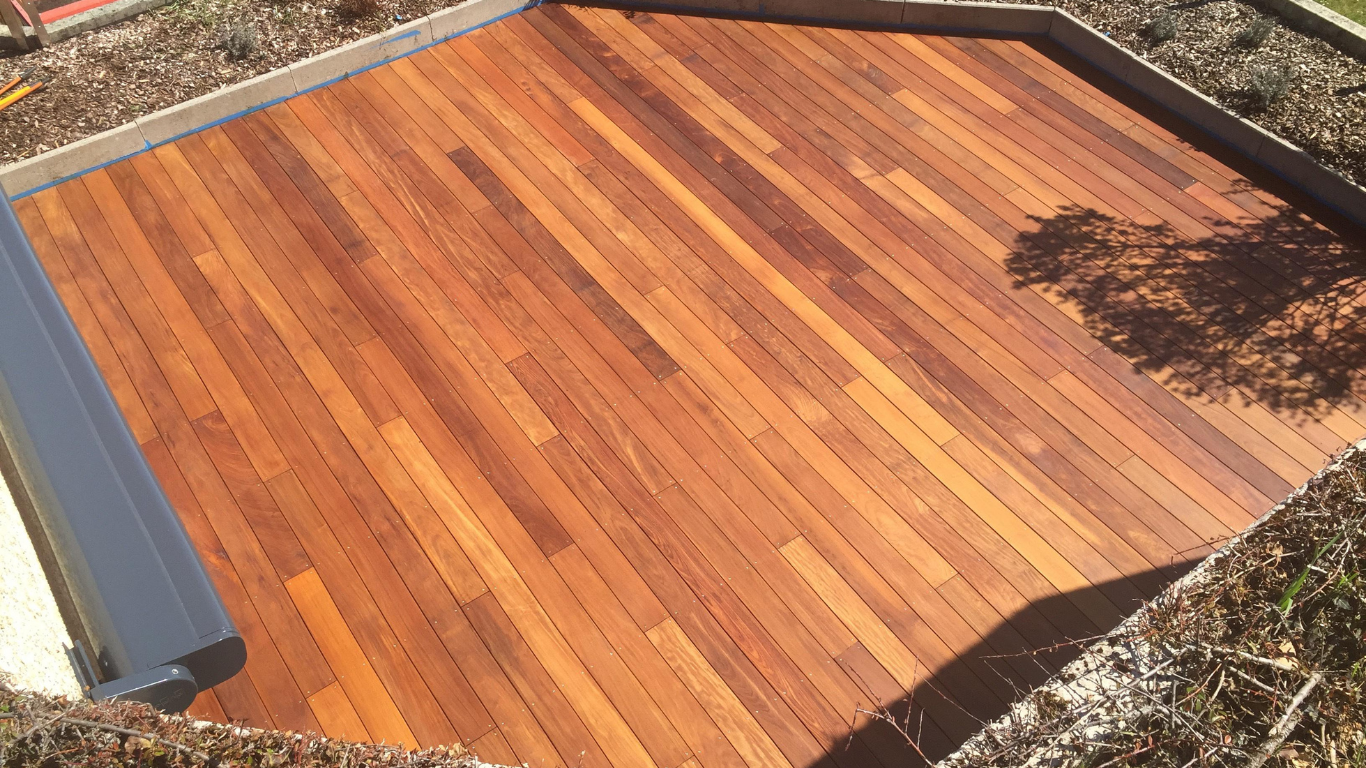 A wooden deck is sitting on top of a lush green field.