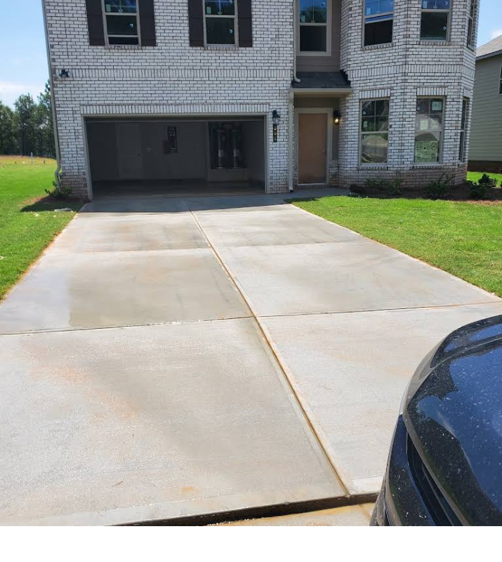 A car is parked in front of a white brick house