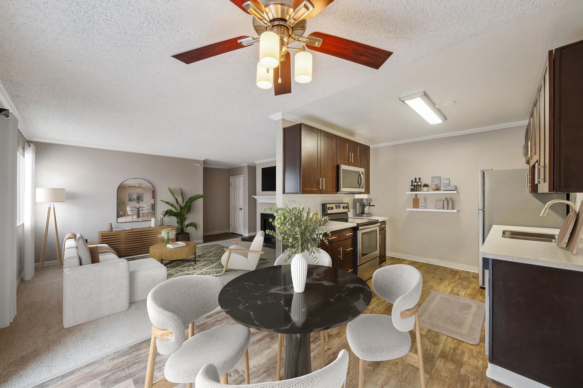 Open-concept living room and kitchen of a modern apartment with dining table and ceiling fan.