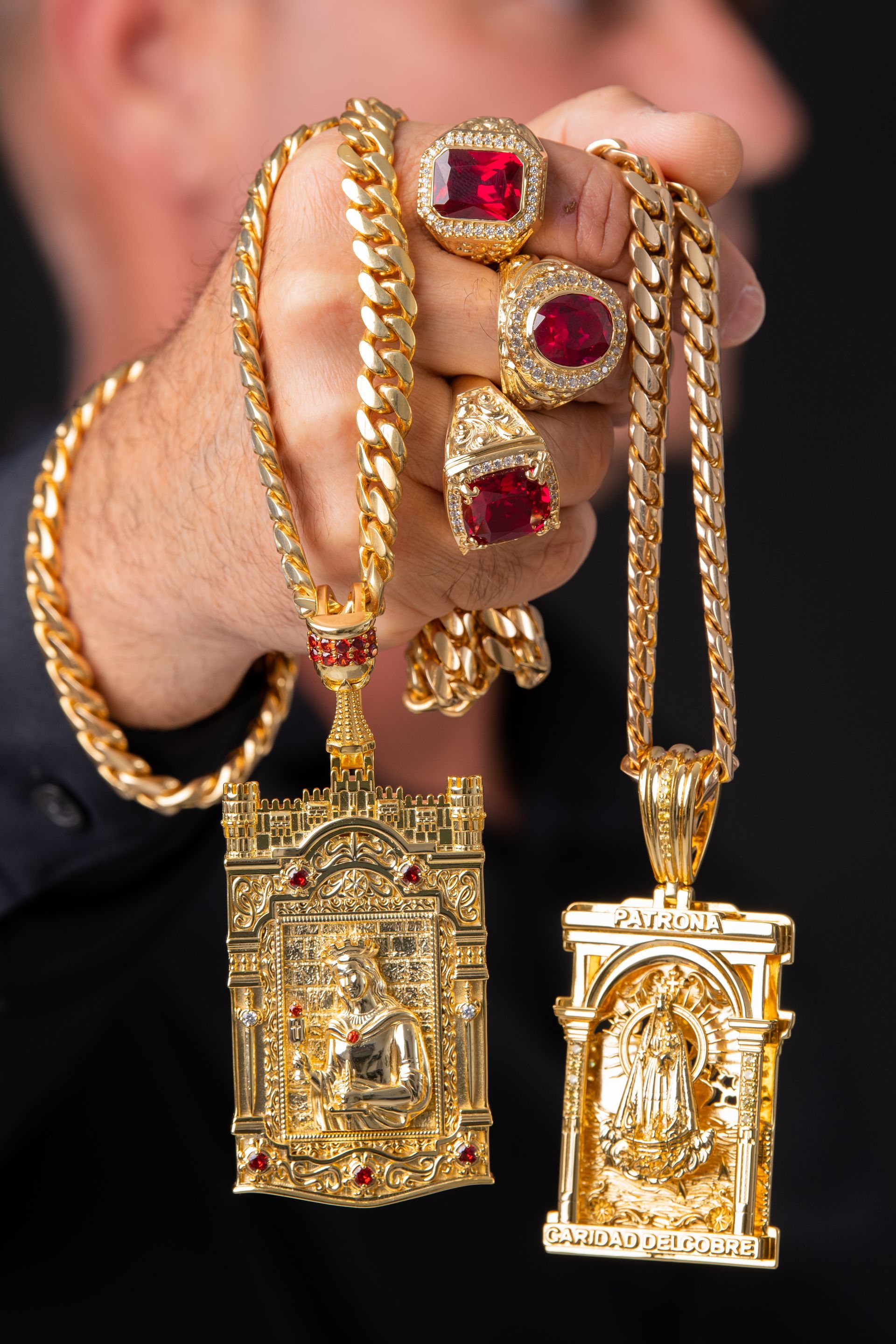 Un hombre sostiene un collar y un colgante en su mano.