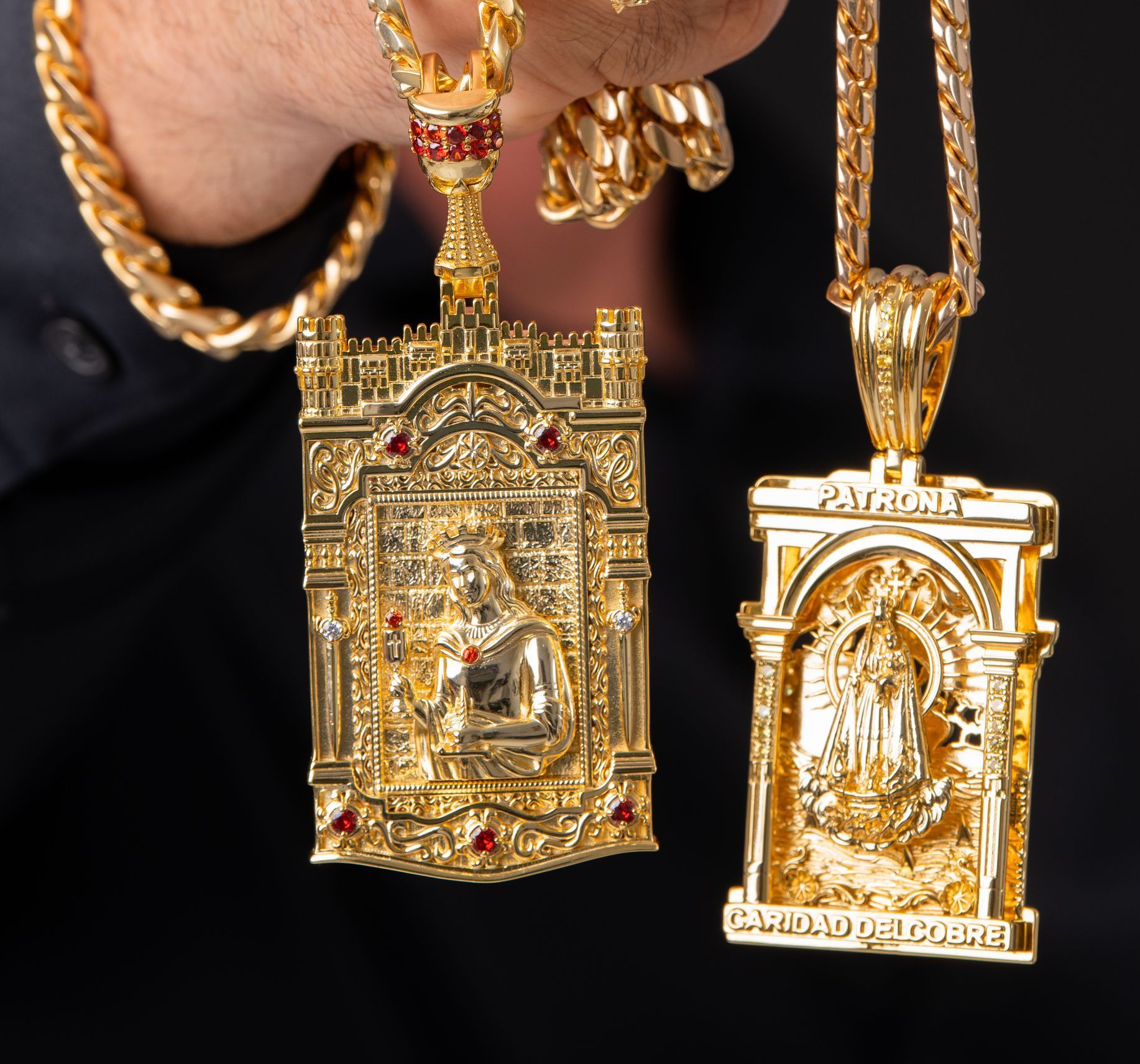 Un hombre sostiene dos colgantes de oro, uno de los cuales tiene la palabra Jesús.