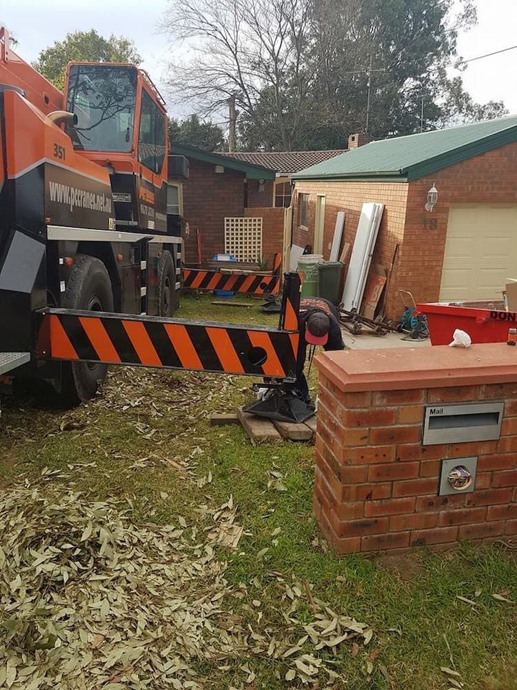 A Construction Worker Adjusting Crane Arm Near a Brick Mailbox in a Residential Yard — Amazon Tree Service in Picton, NSW
