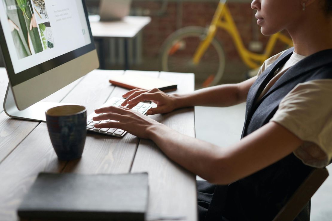 A man is sitting at a desk typing on a computer keyboard.