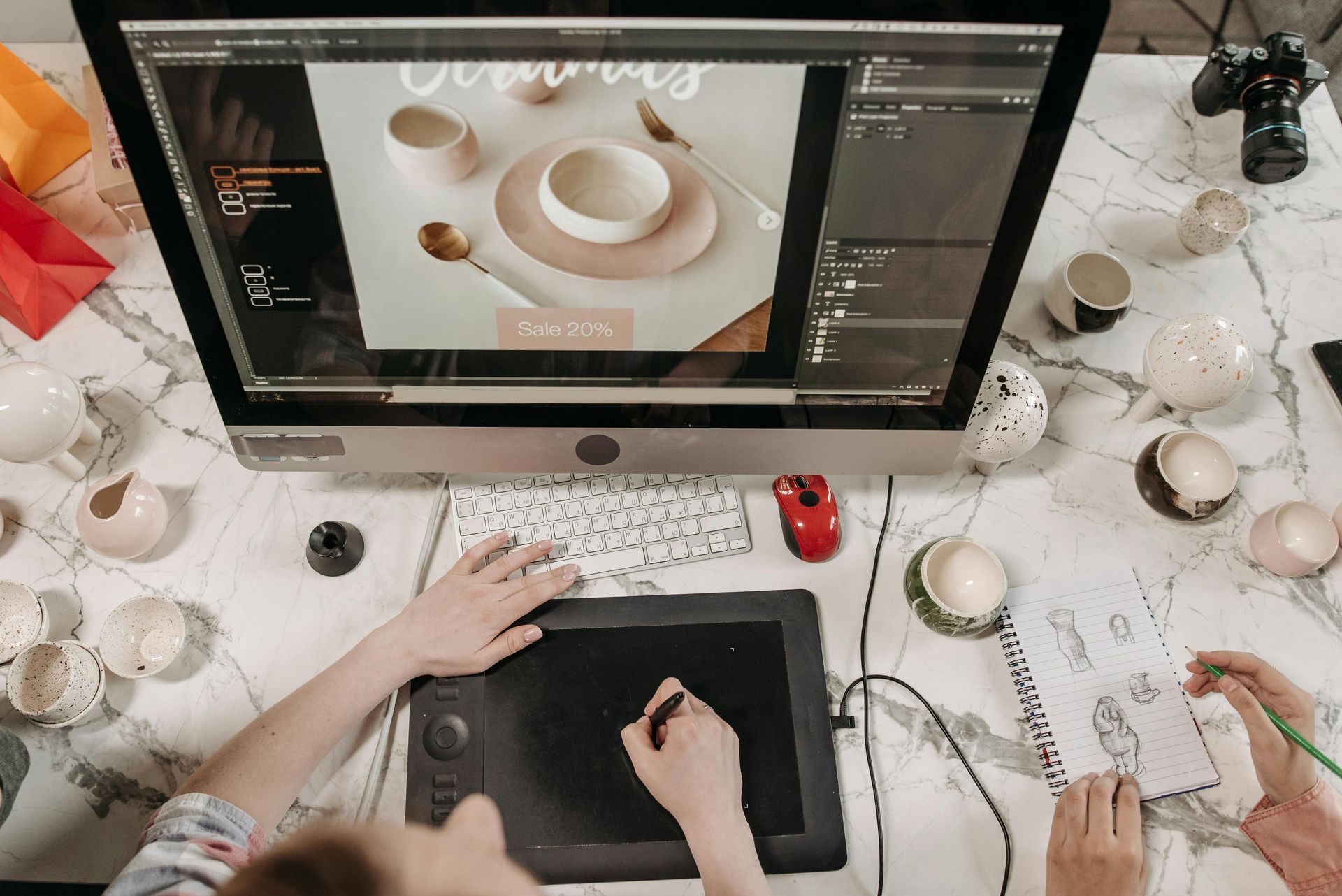 A person is using a graphic tablet to draw on a computer screen.