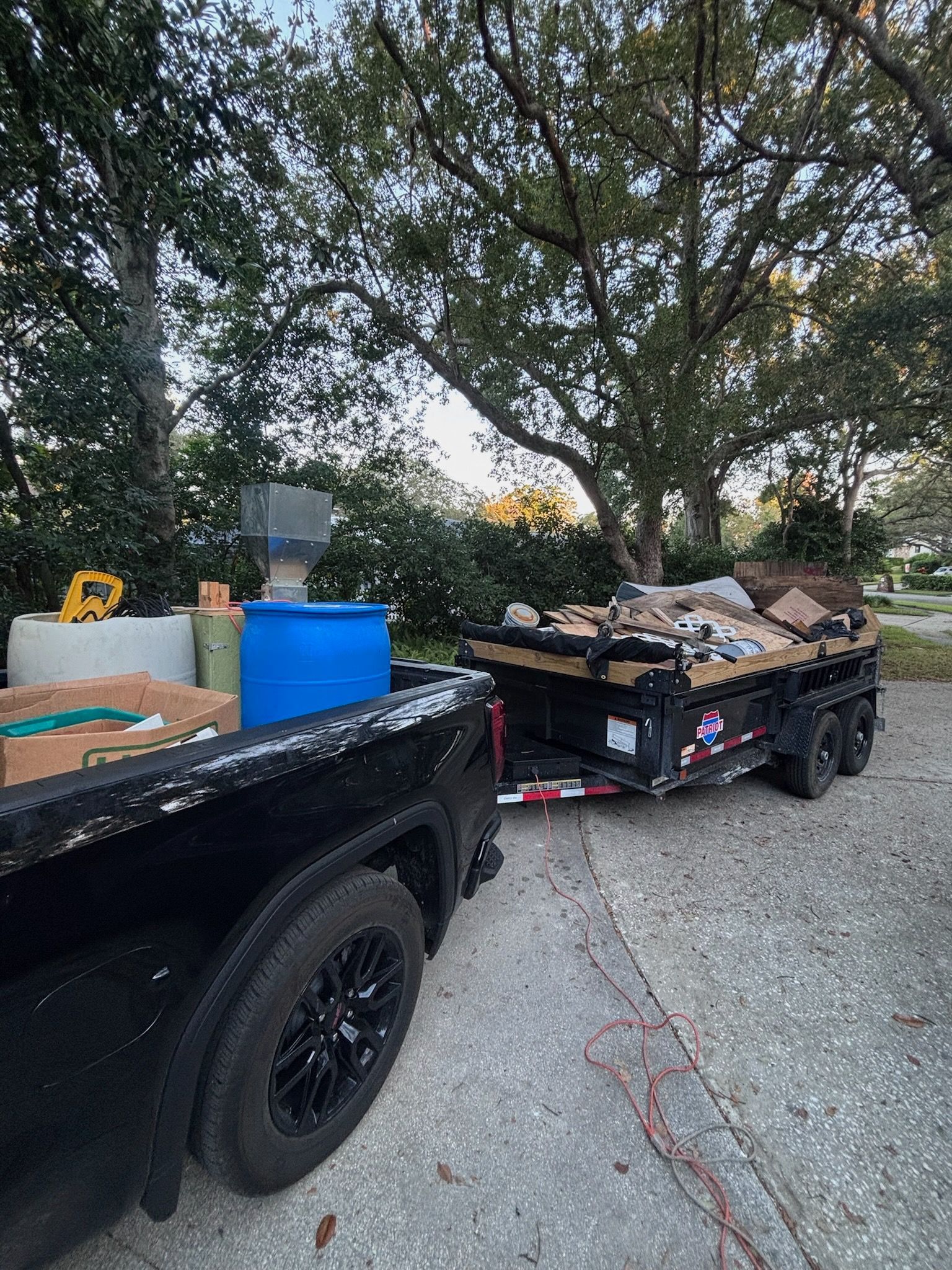 A red truck is loaded with a lot of junk in the back.