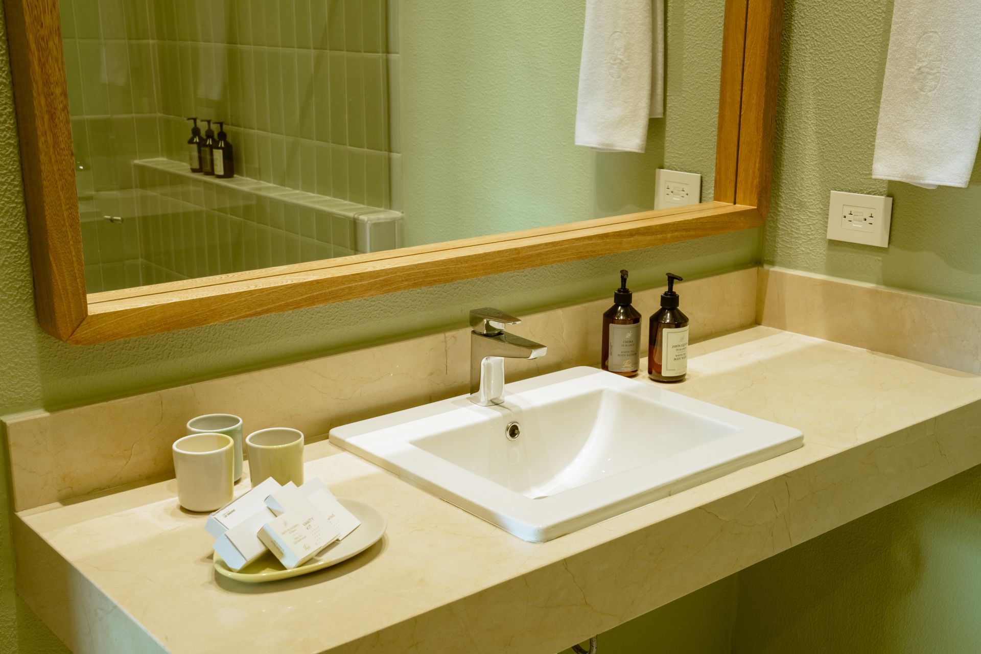 Un baño con lavabo y un espejo grande.