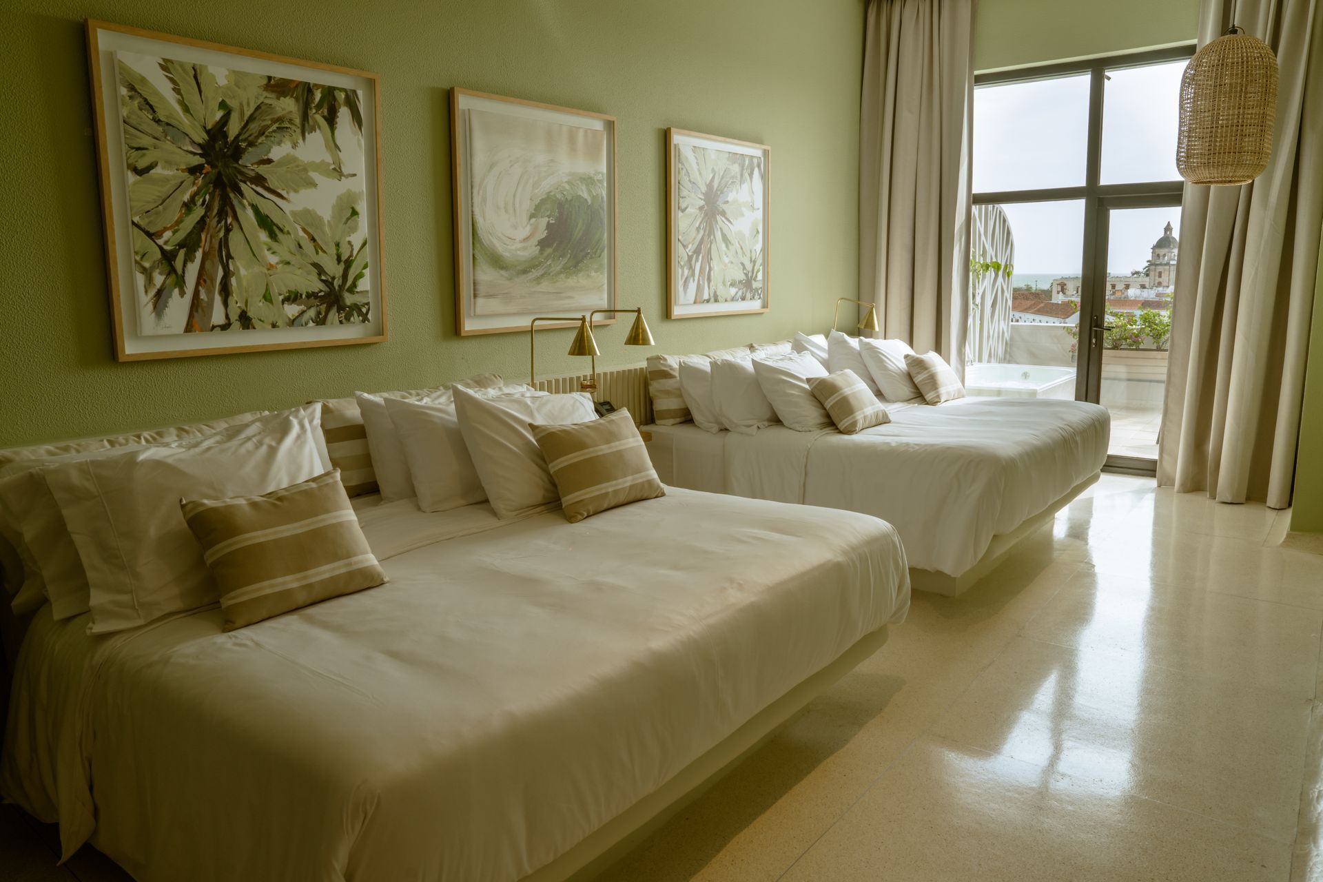 Una habitación de hotel con tres camas y una gran ventana.