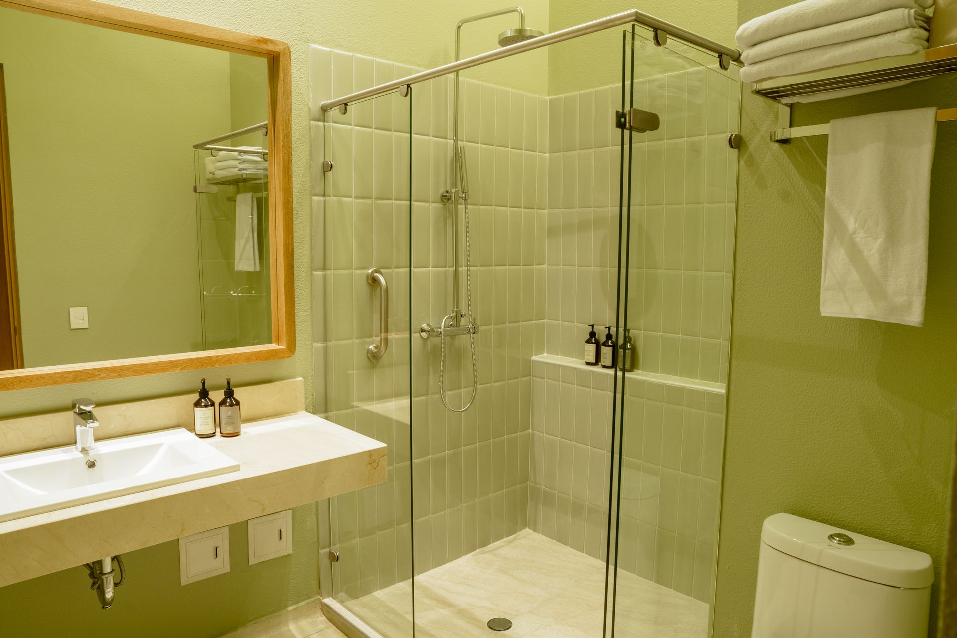 Un baño con inodoro, lavabo, ducha y espejo.