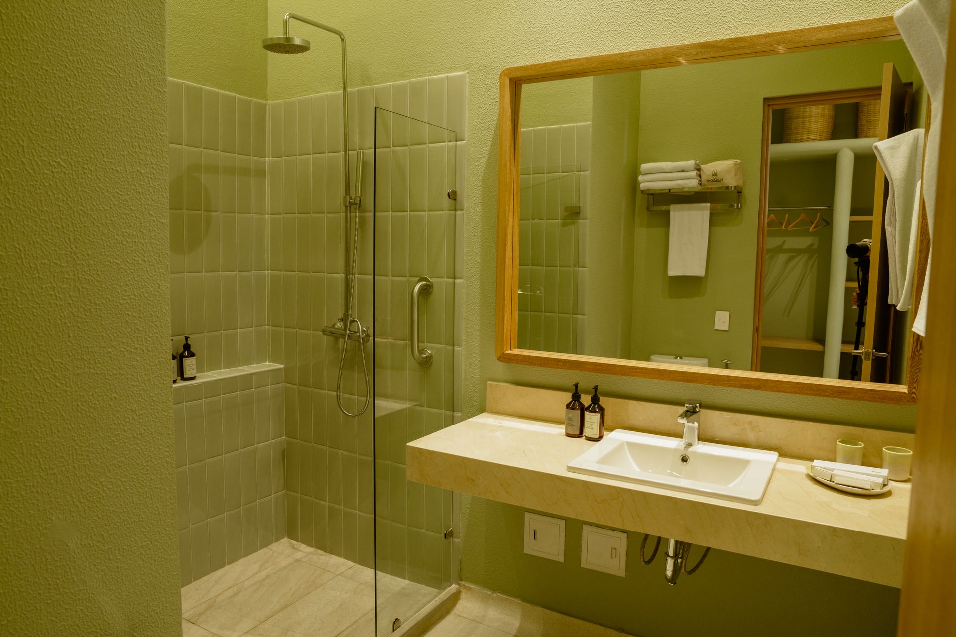 Un baño con lavabo, espejo y ducha.