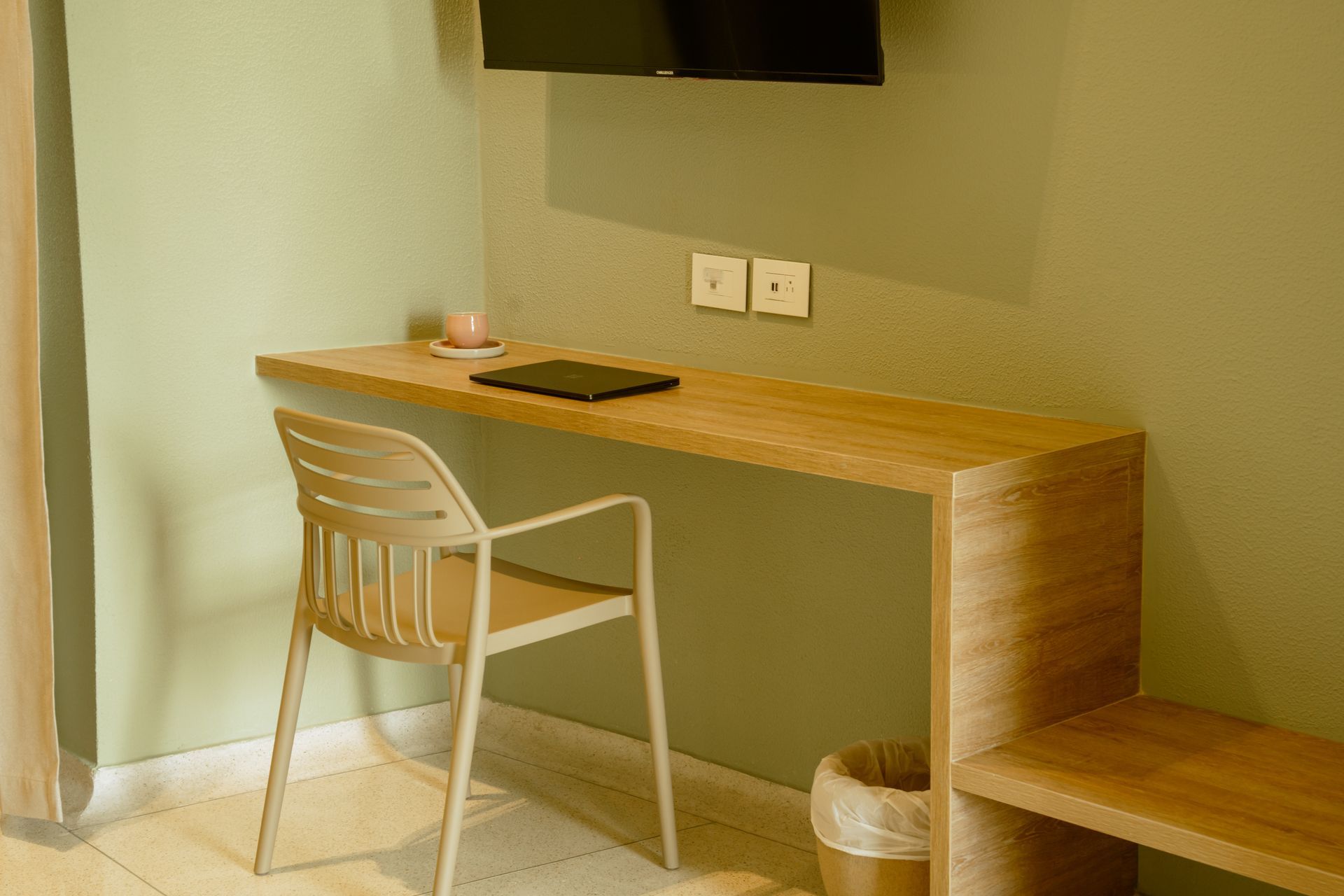 Una silla está sentada en un escritorio en una habitación de hotel.