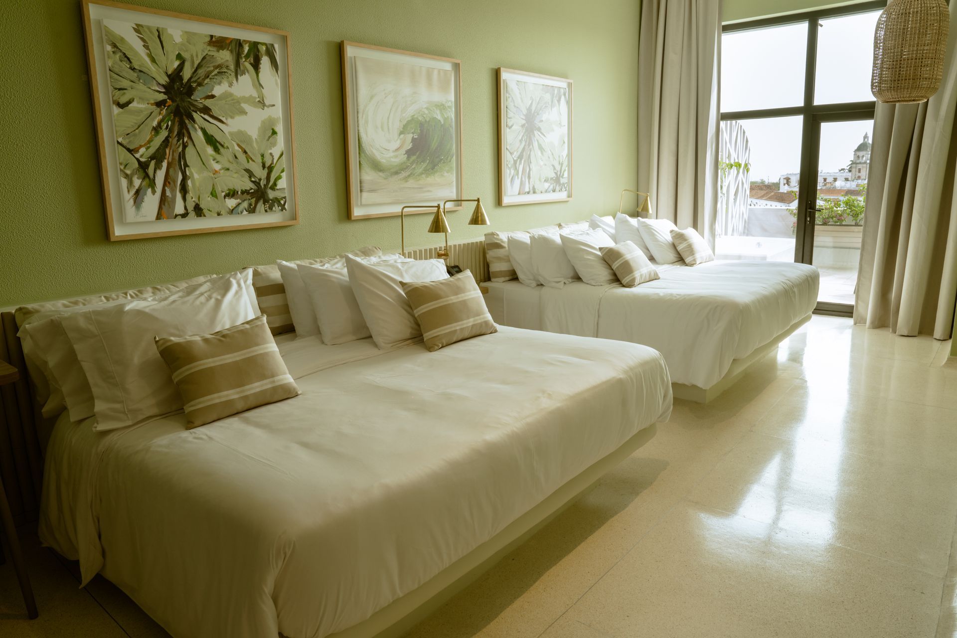 Una habitación de hotel con tres camas y una gran ventana.