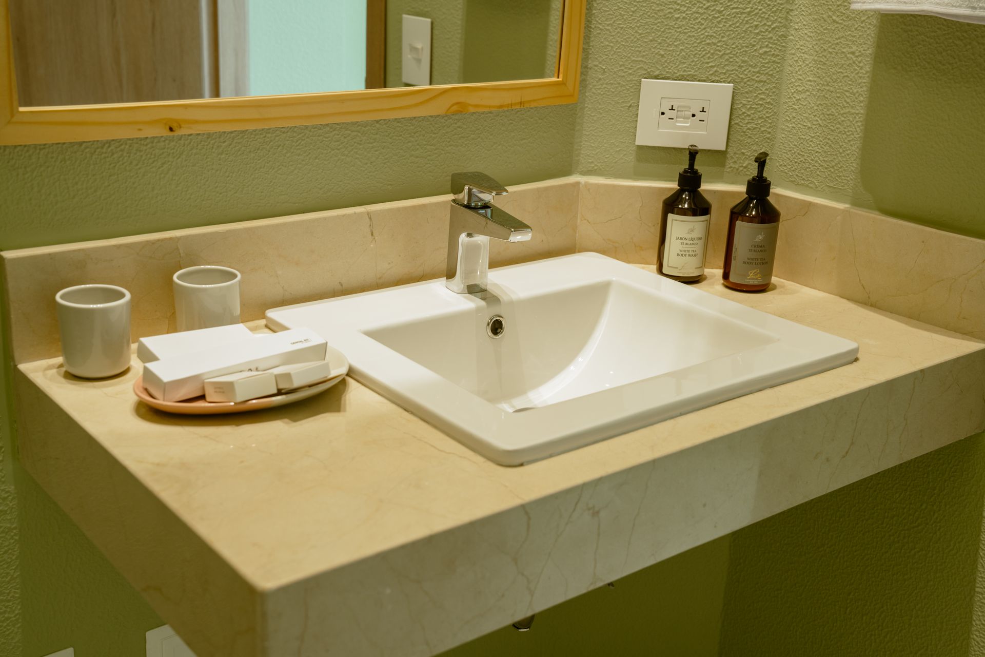 Un lavabo de baño con dos botellas de jabón encima.