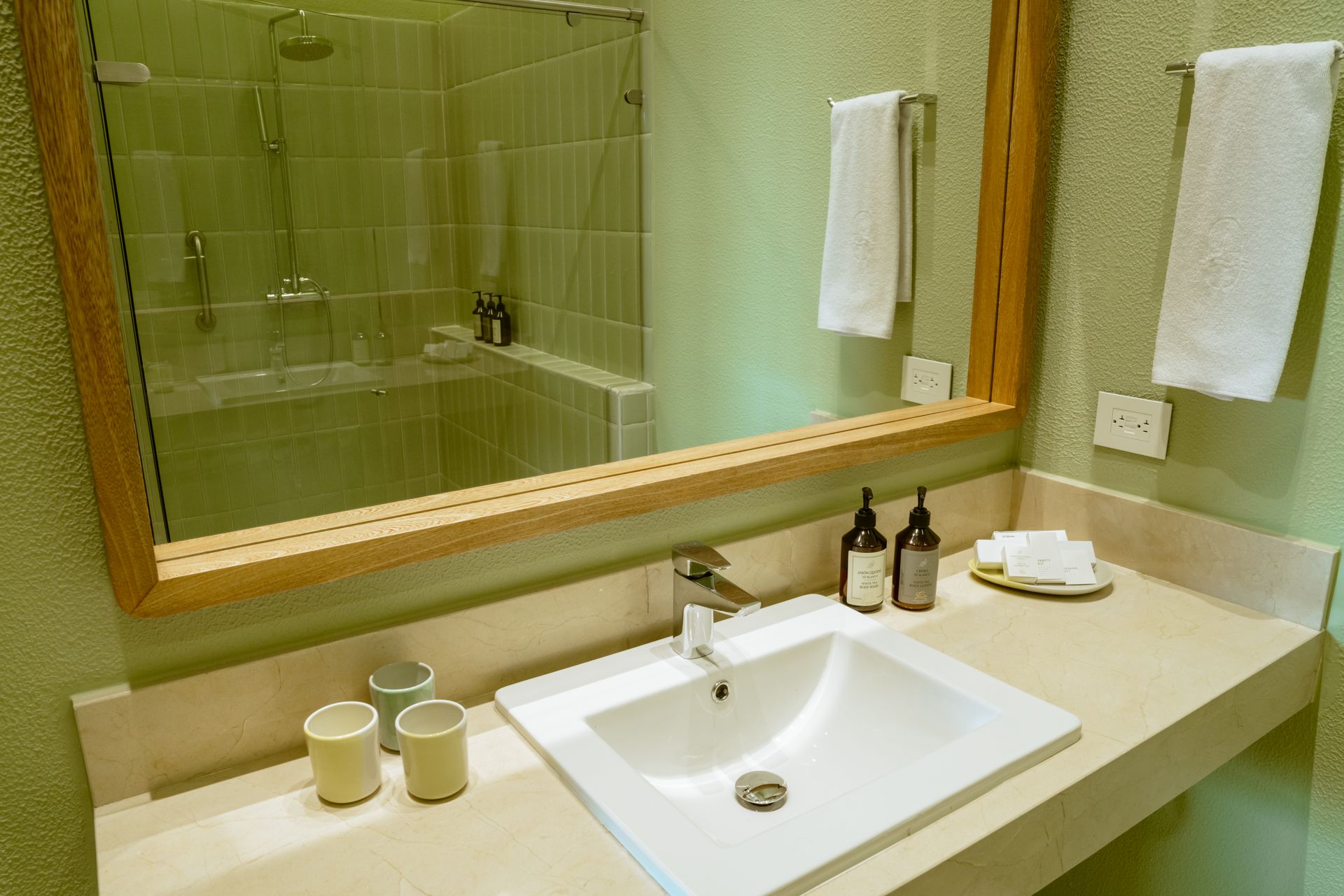 Un baño con lavabo, espejo y ducha.