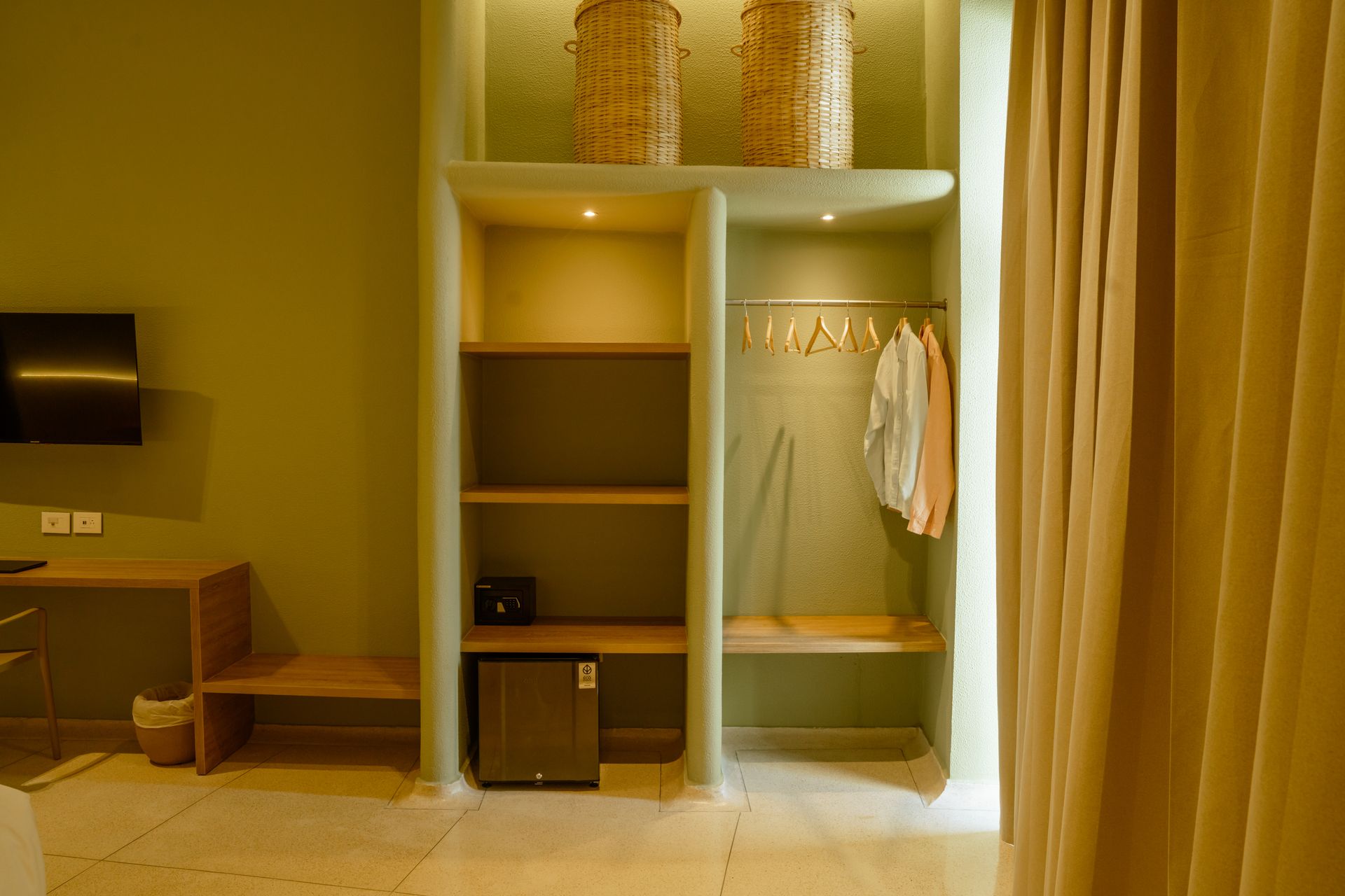 Una habitación de hotel con armario, escritorio y televisión.