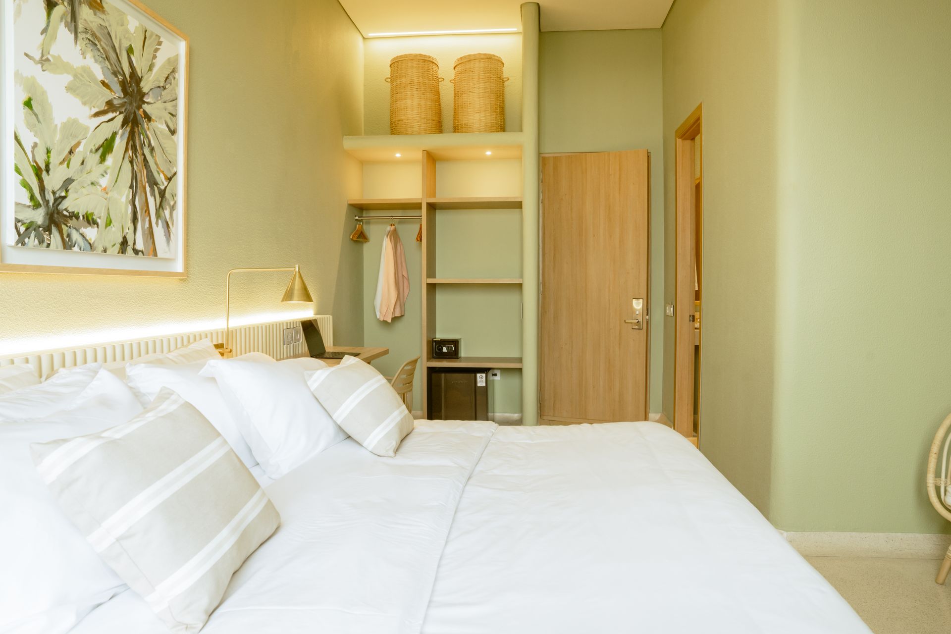 Una habitación de hotel con una cama, una silla, un escritorio y un armario.