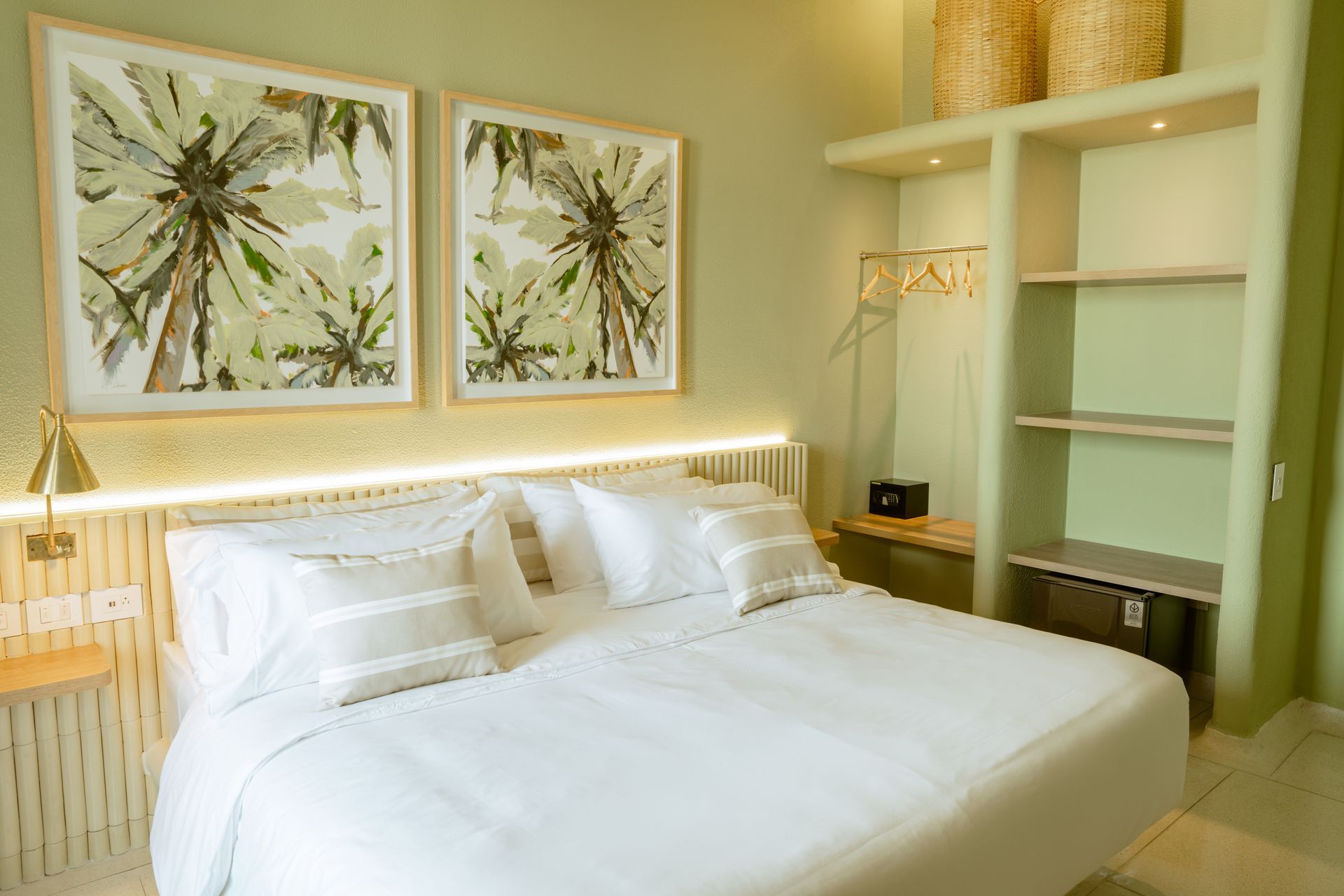 Un dormitorio con una cama king size y dos cuadros en la pared.