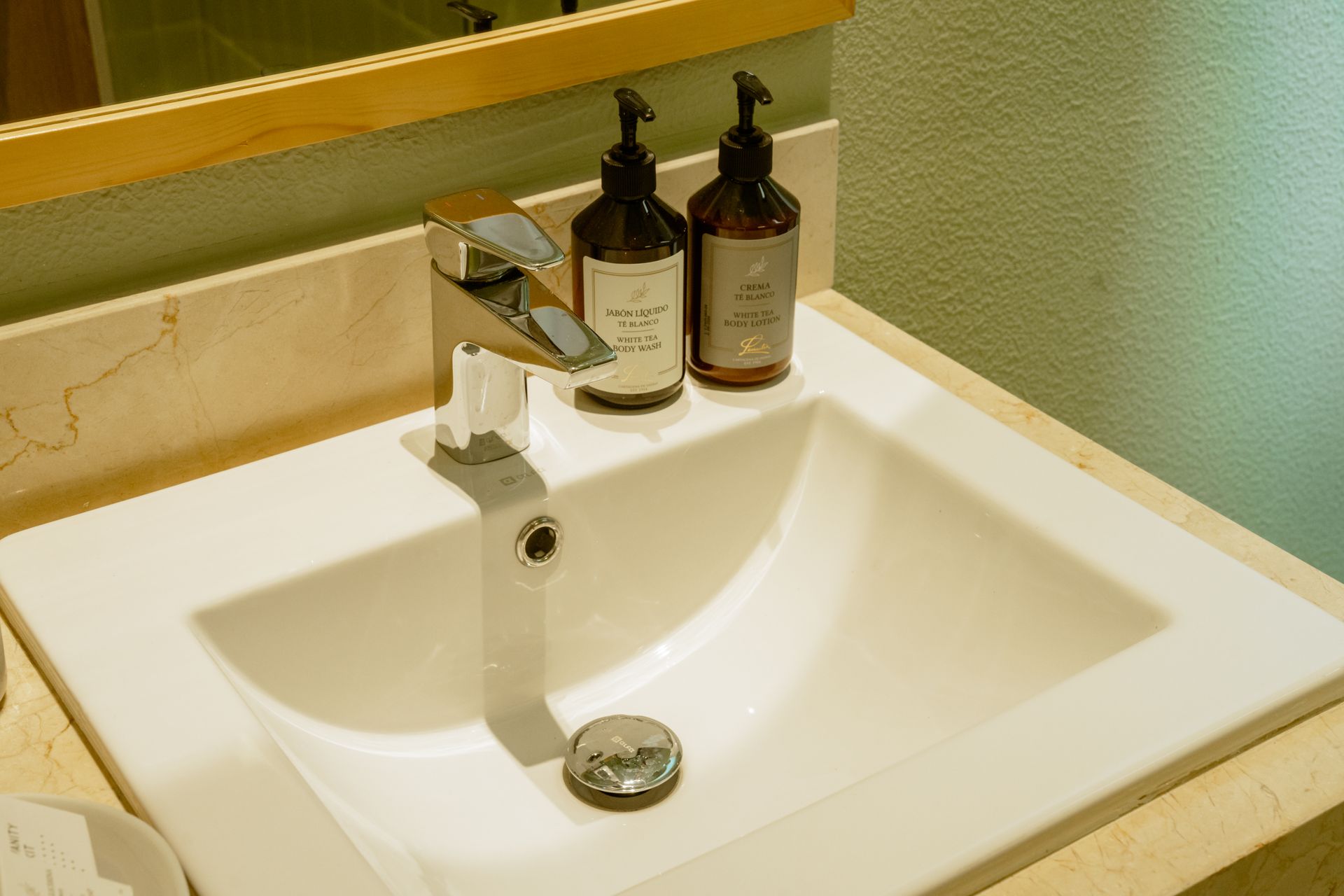 Un lavabo de baño con dos botellas de jabón encima.