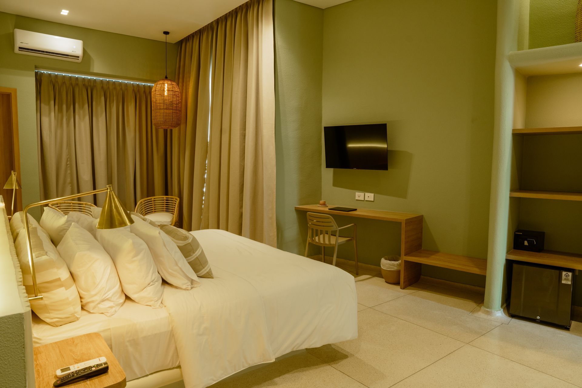 Una habitación de hotel con cama, escritorio y televisión.