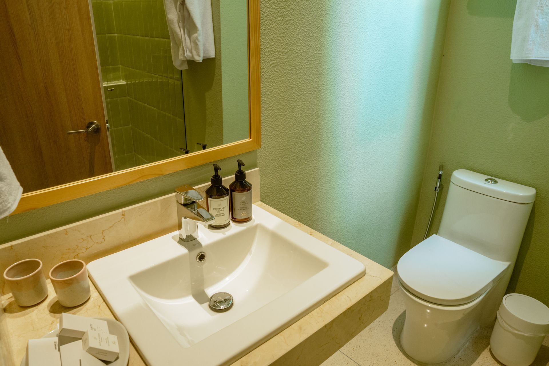 Un baño con lavabo, inodoro y espejo.