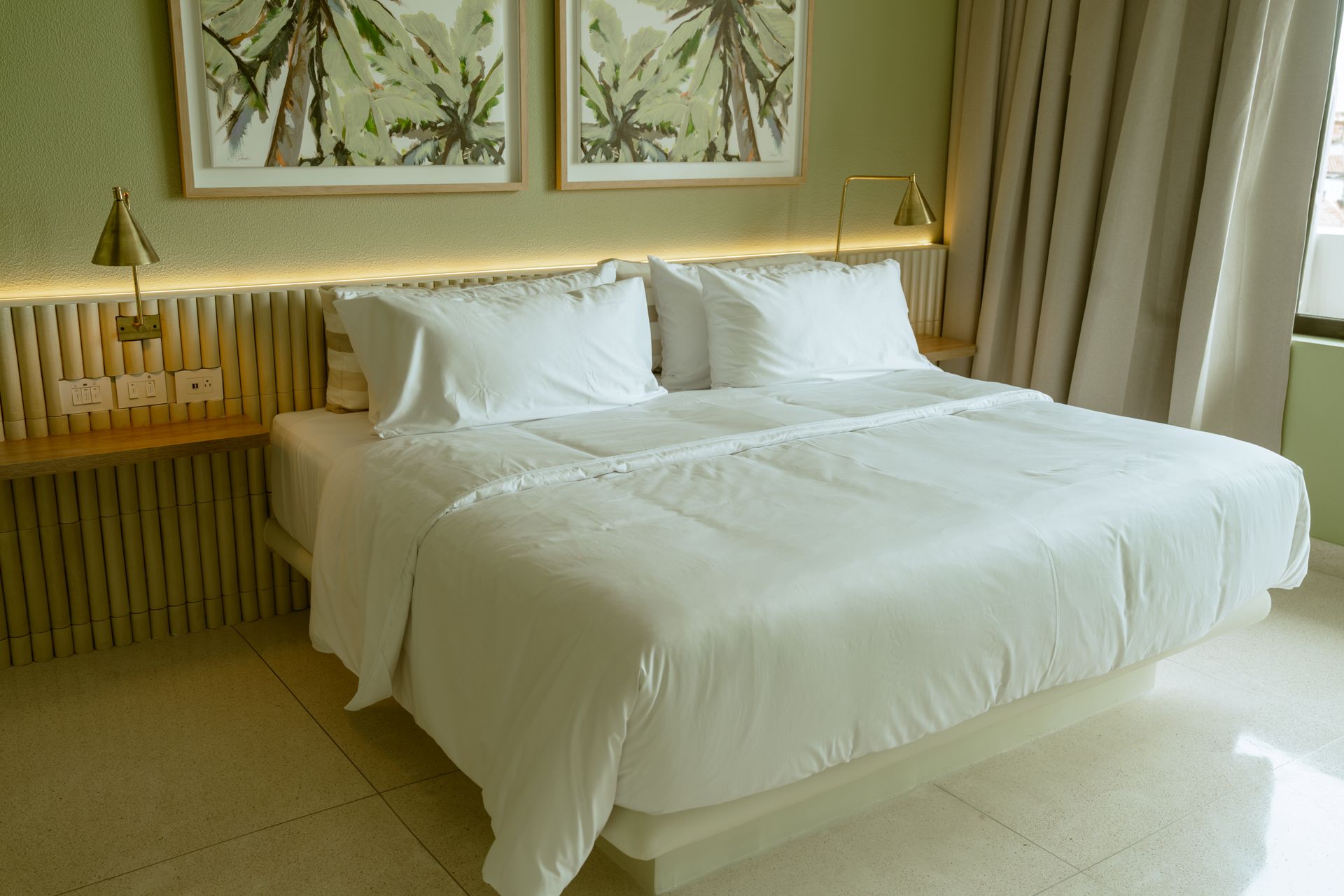 Una habitación de hotel con una cama y dos cuadros en la pared.