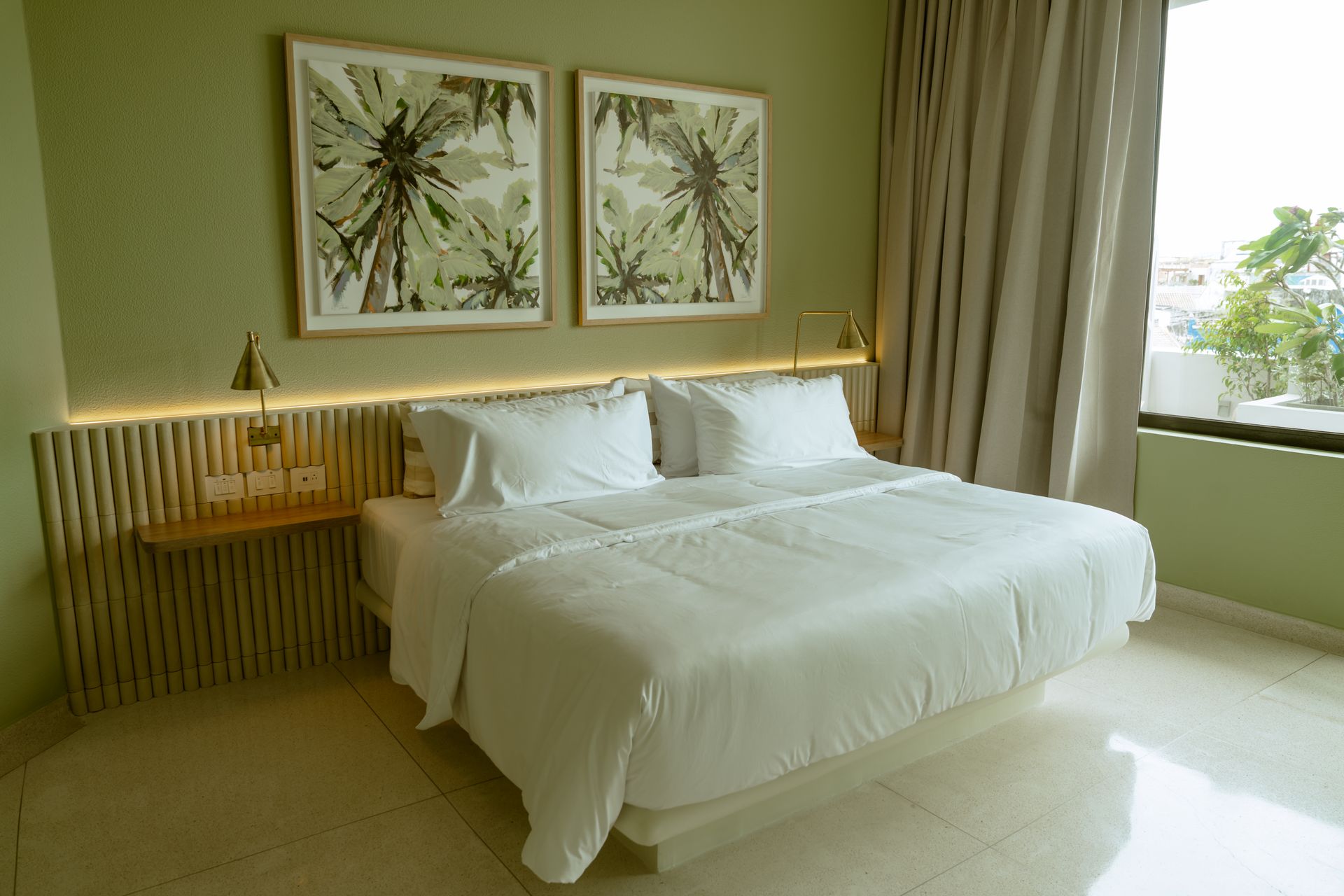 Una habitación de hotel con una cama tamaño king y dos cuadros en la pared.