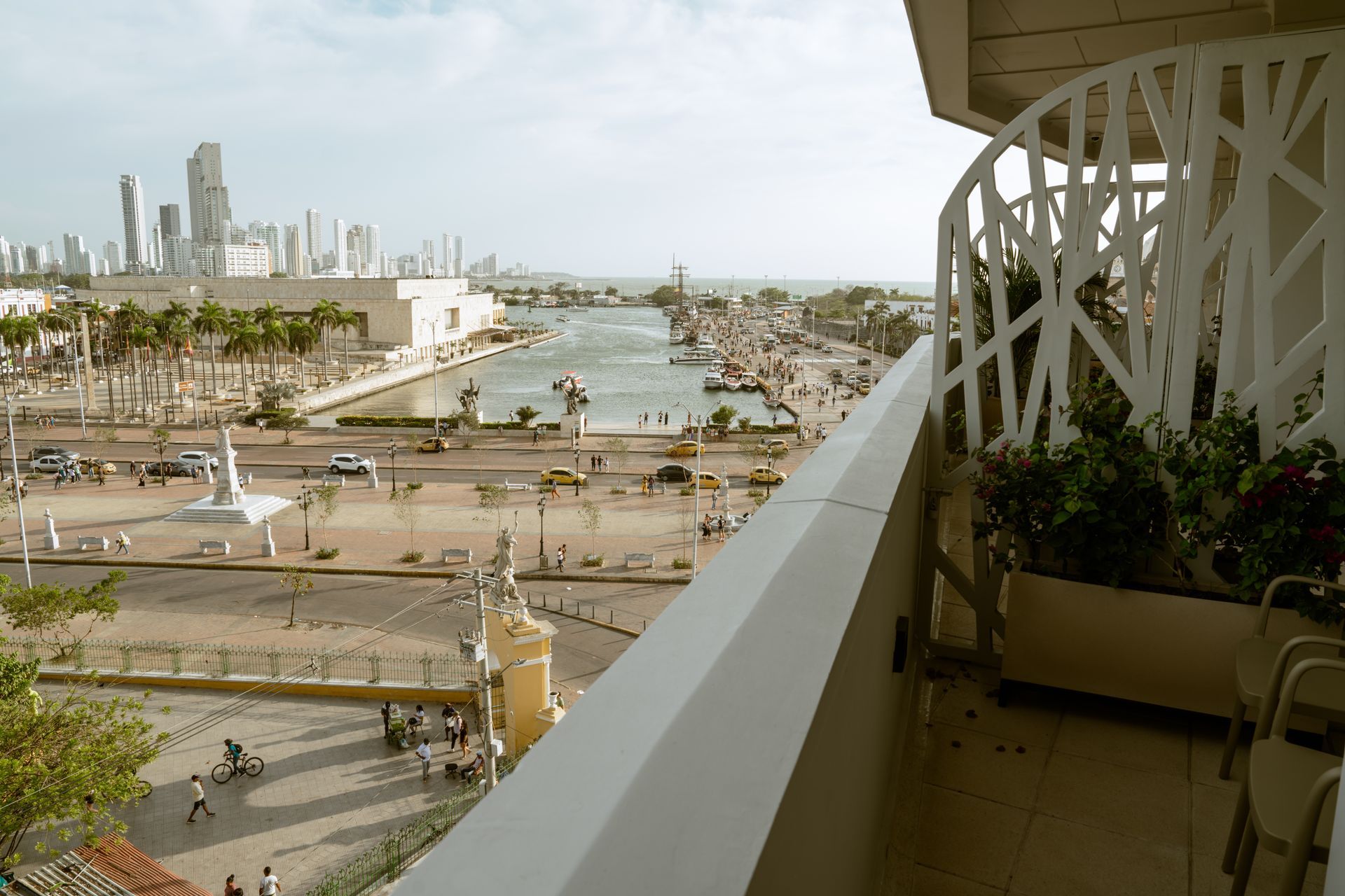 Una vista de una ciudad desde un balcón con barandilla blanca.