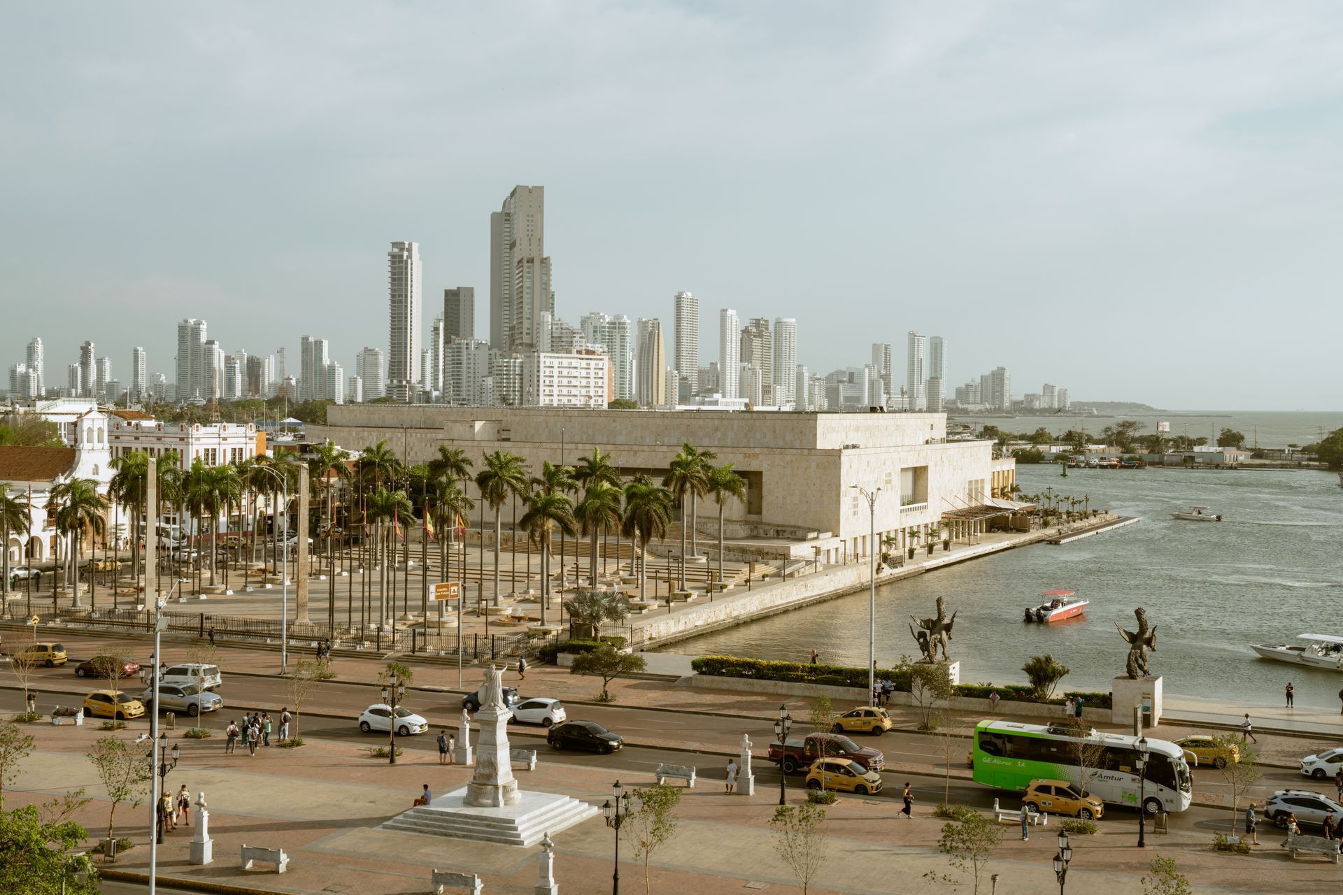 Una vista aérea de una ciudad con un río en primer plano y un horizonte de ciudad en el fondo.