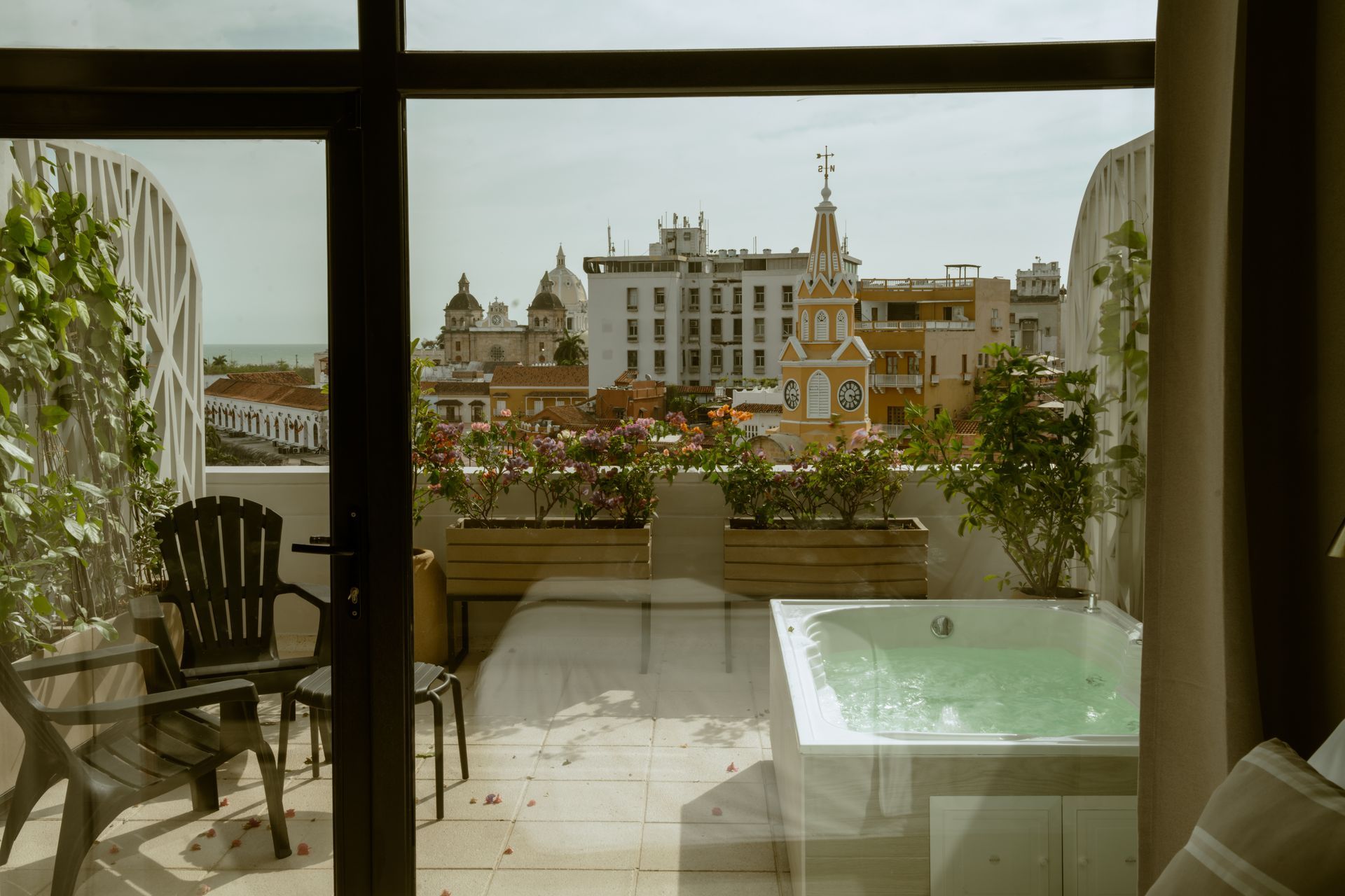 Una vista de una ciudad desde una habitación de hotel con bañera de hidromasaje.