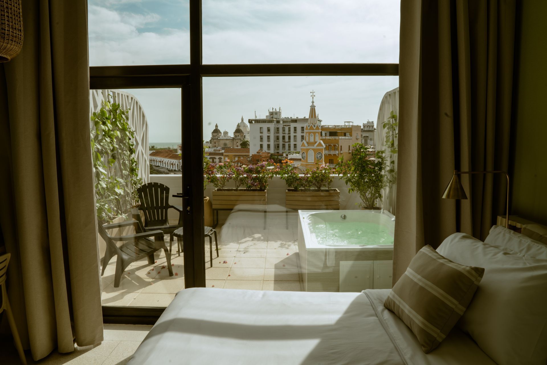 Una habitación de hotel con una cama, sillas y un jacuzzi.