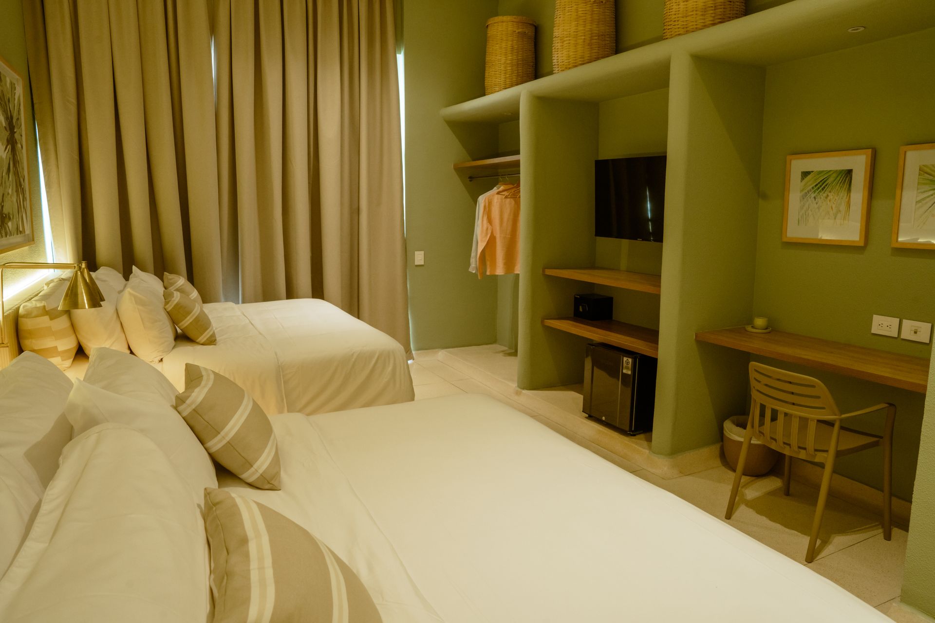 Una habitación de hotel con dos camas, un escritorio y un televisor.