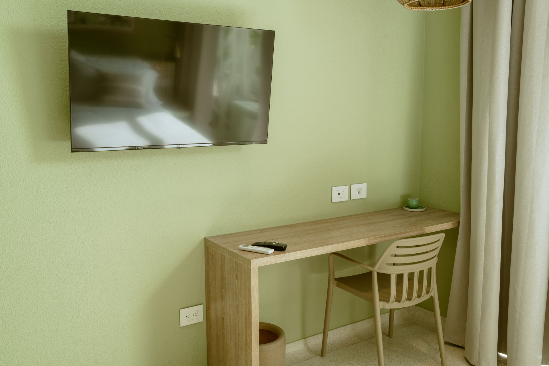Un escritorio con una silla y un televisor de pantalla plana en la pared.