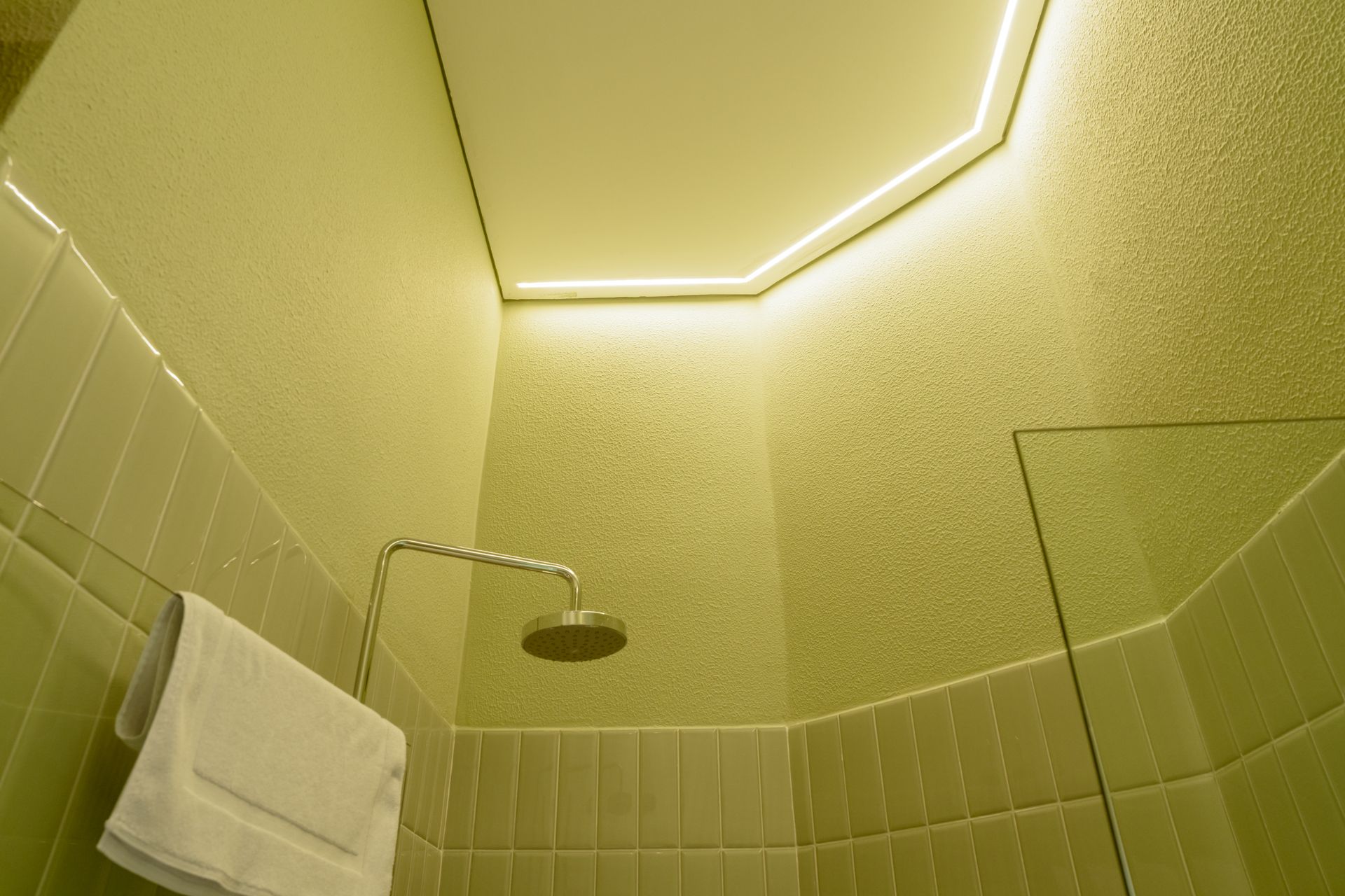 Un baño con ducha y una toalla colgada en la pared.