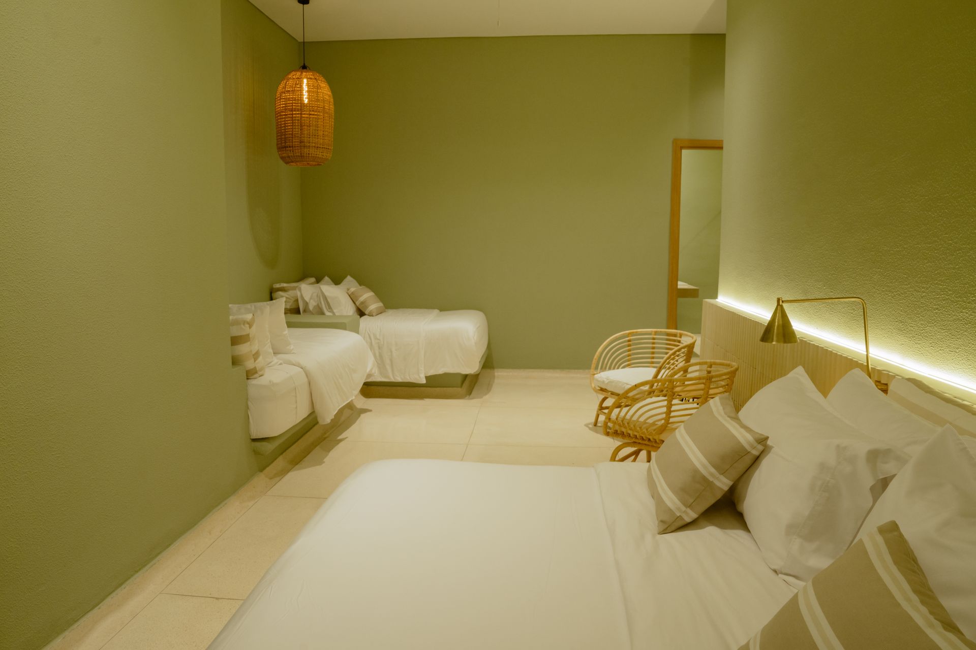 Una habitación de hotel con dos camas, una silla y un espejo.