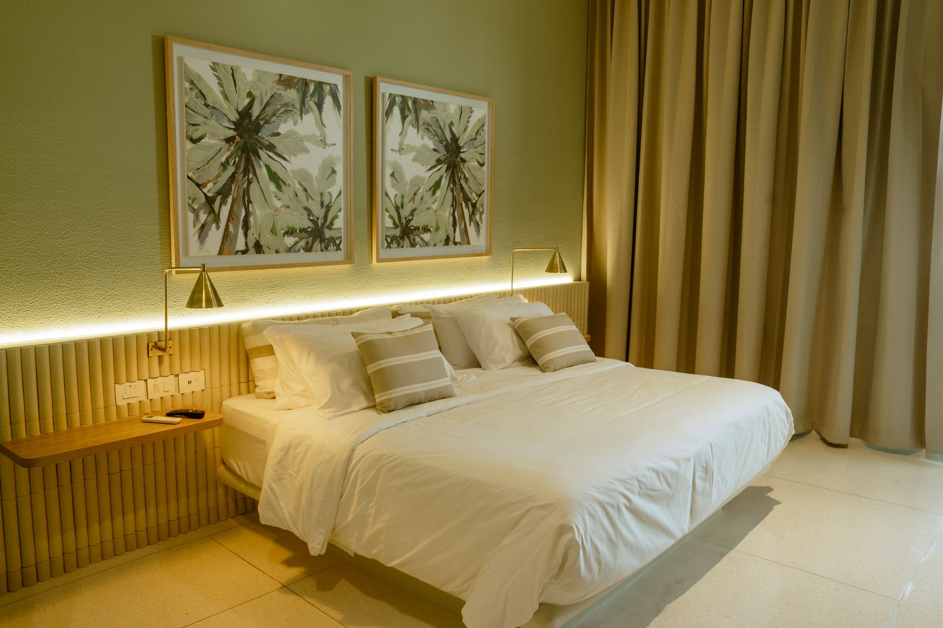 Una habitación de hotel con una cama tamaño king y dos cuadros en la pared.