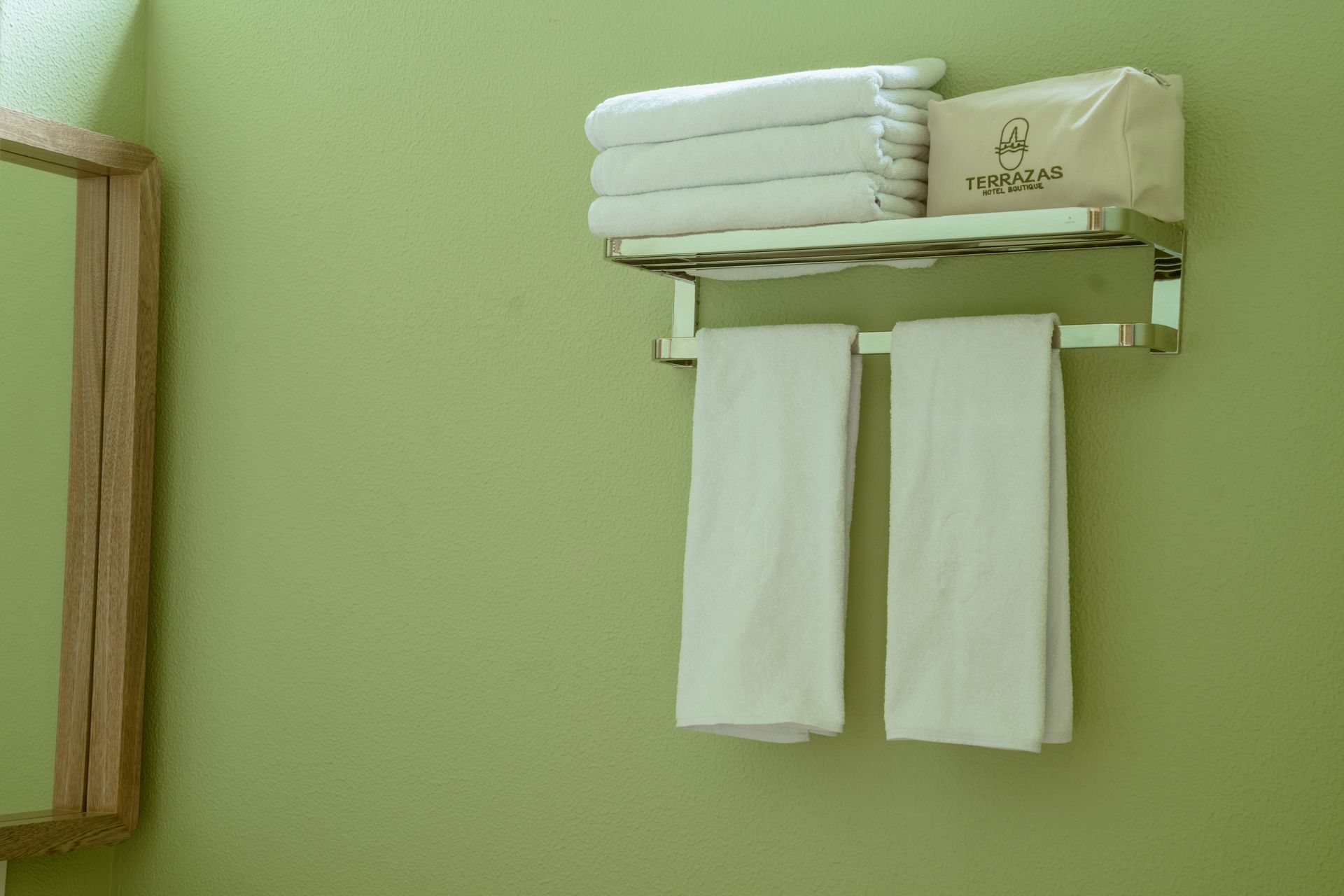 Dos toallas están colgadas en un toallero al lado de un espejo.