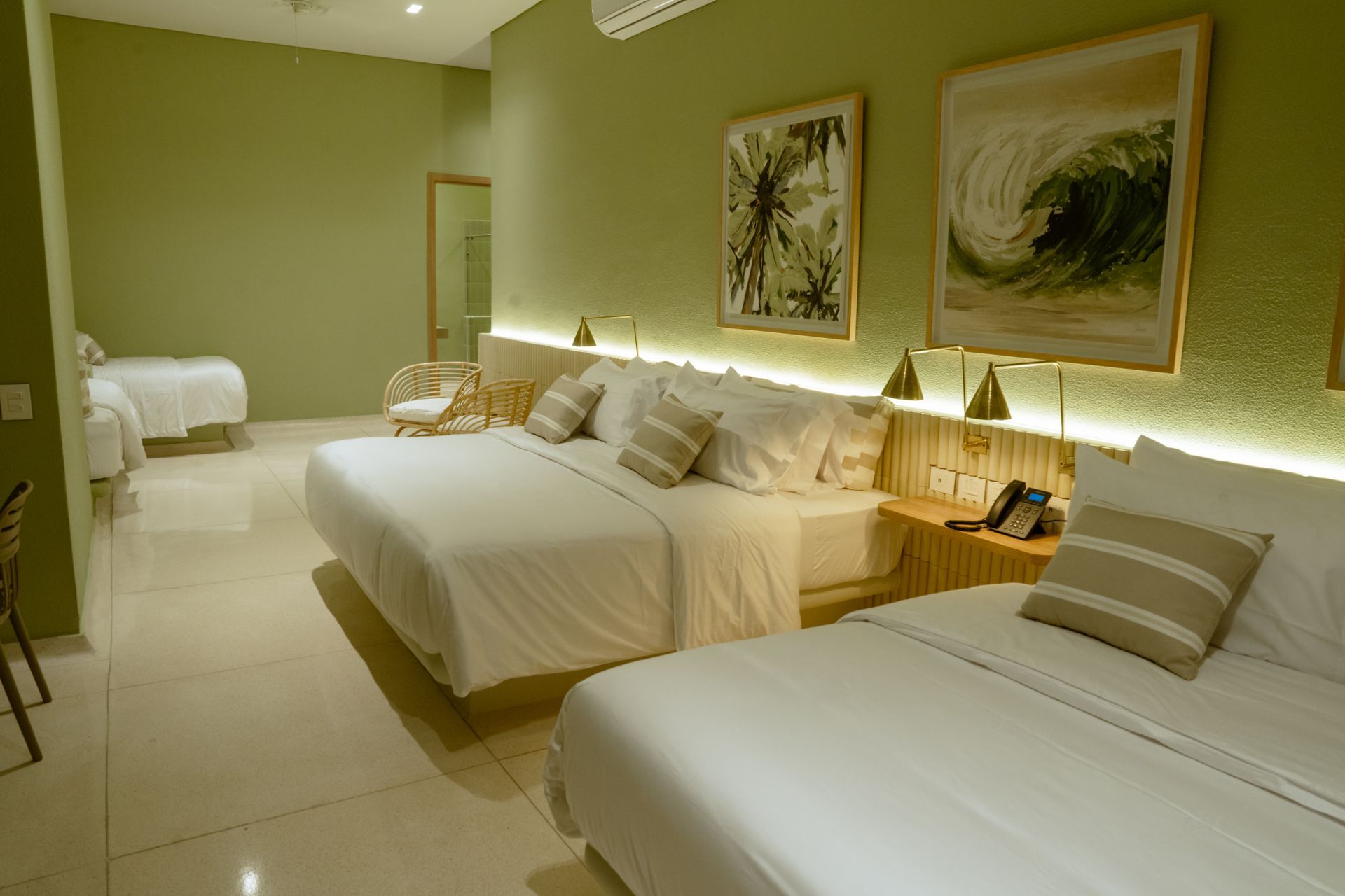 Una habitación de hotel con dos camas y dos cuadros en la pared.