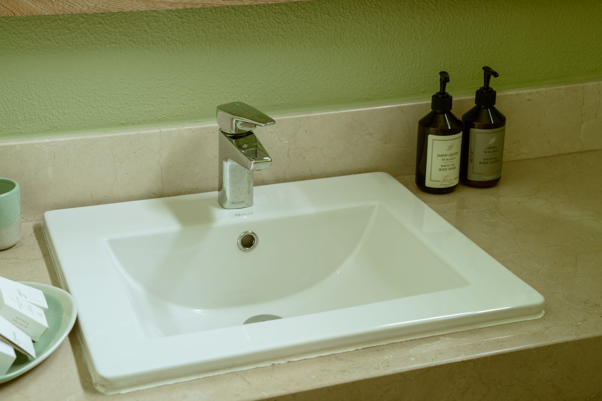 Un lavabo de baño con dos botellas de jabón en el mostrador.