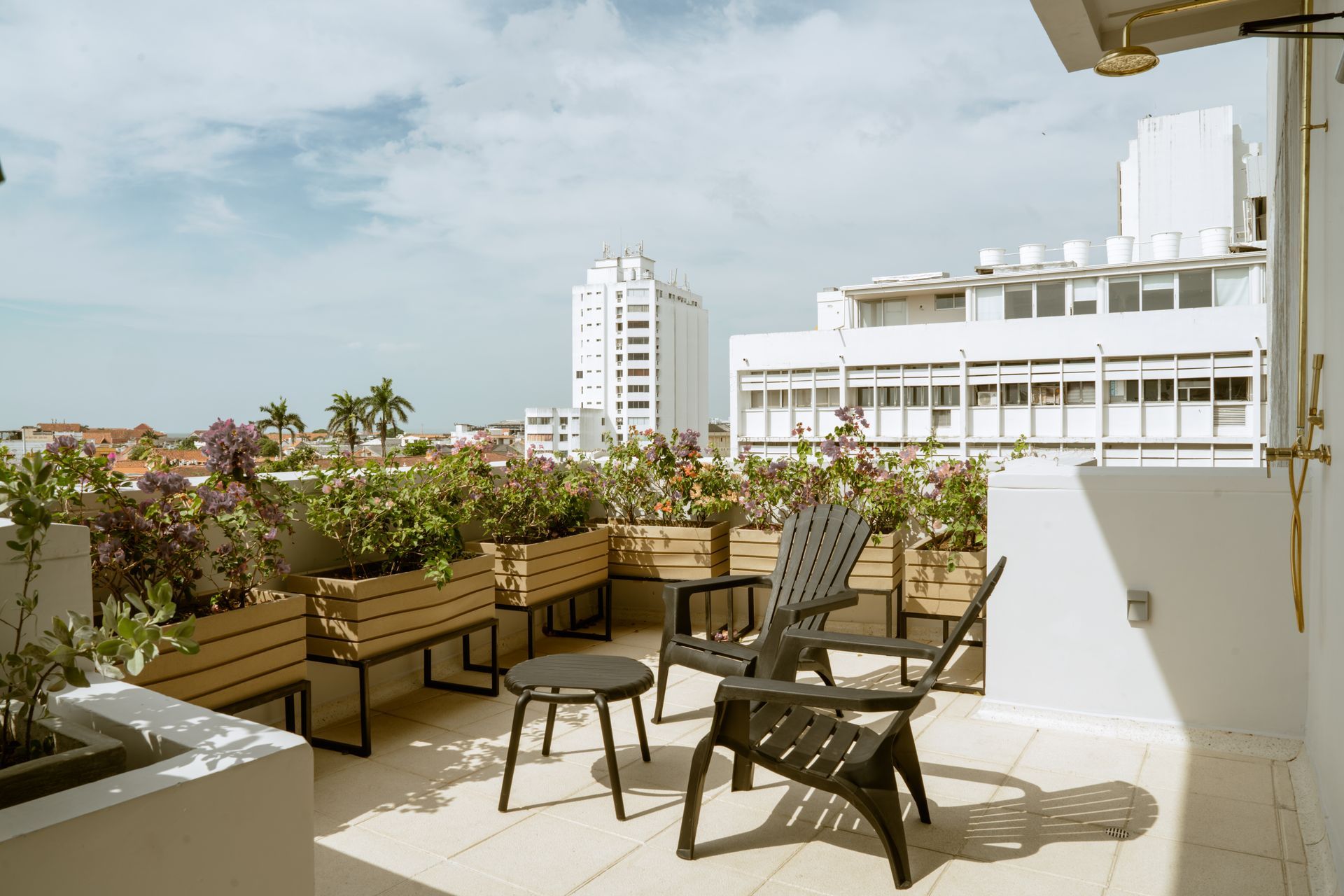 Un balcón con sillas y una mesa con vista a la ciudad.