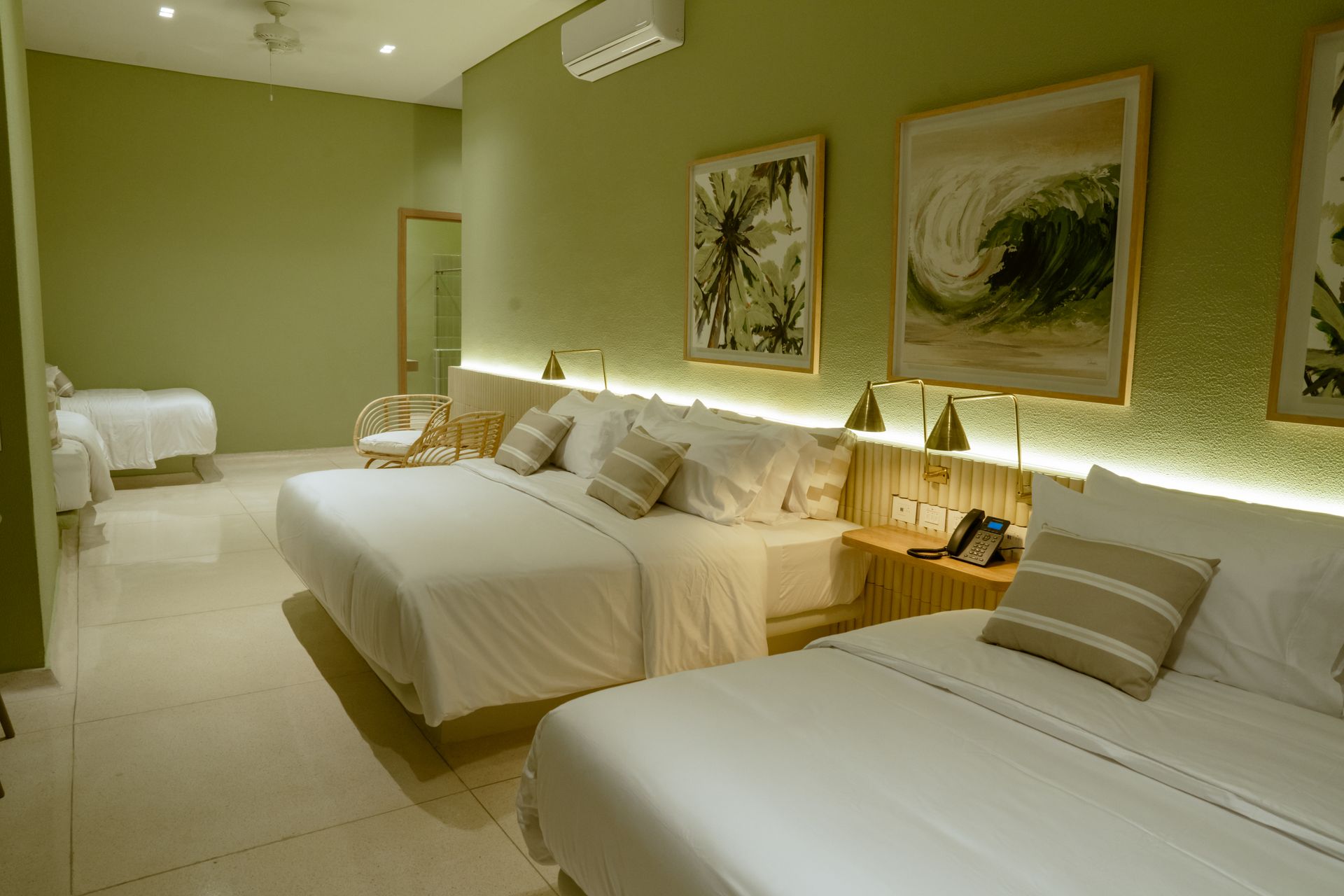 Una habitación de hotel con dos camas, una silla y un espejo.