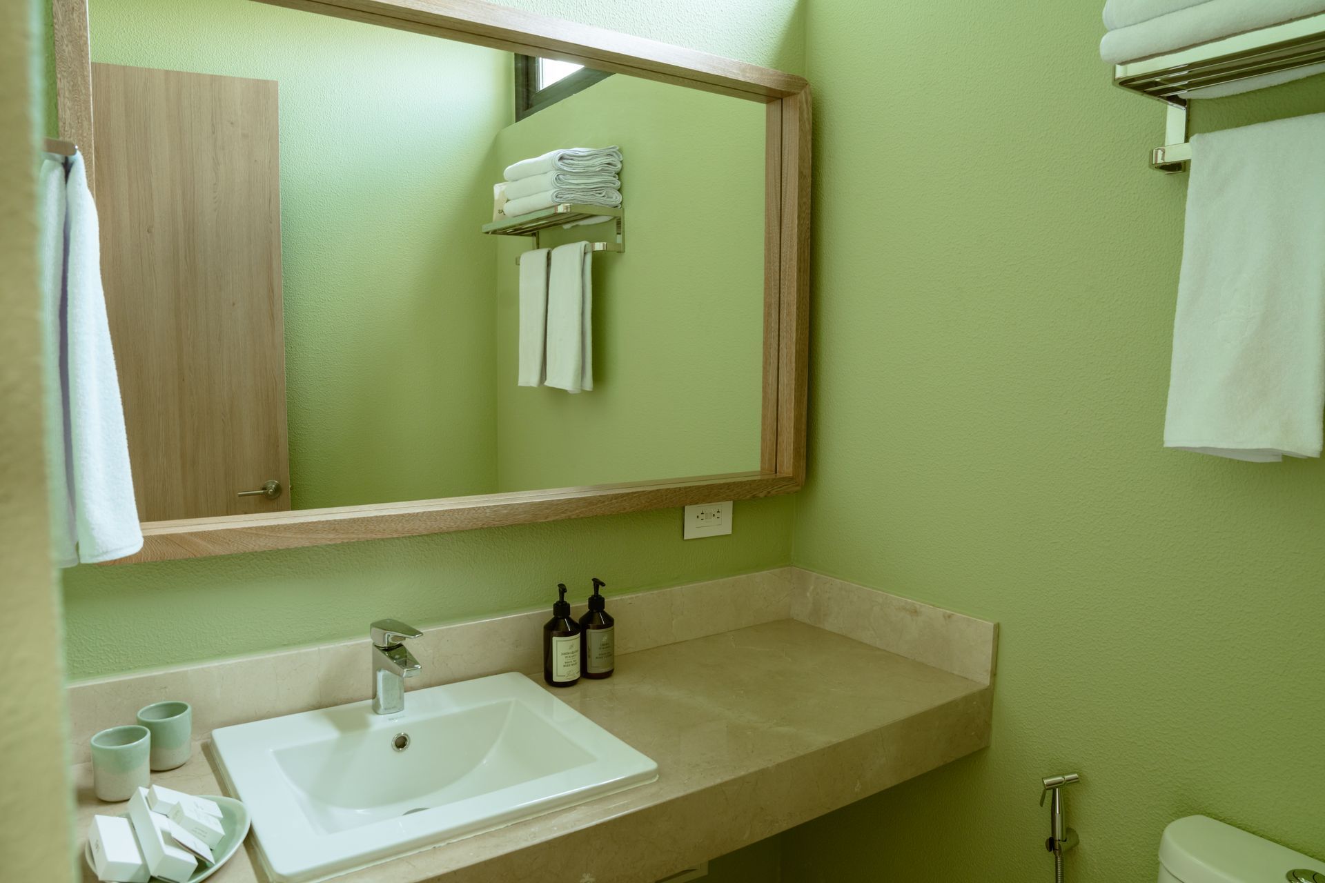 Un baño con lavabo, inodoro, espejo y toallas.