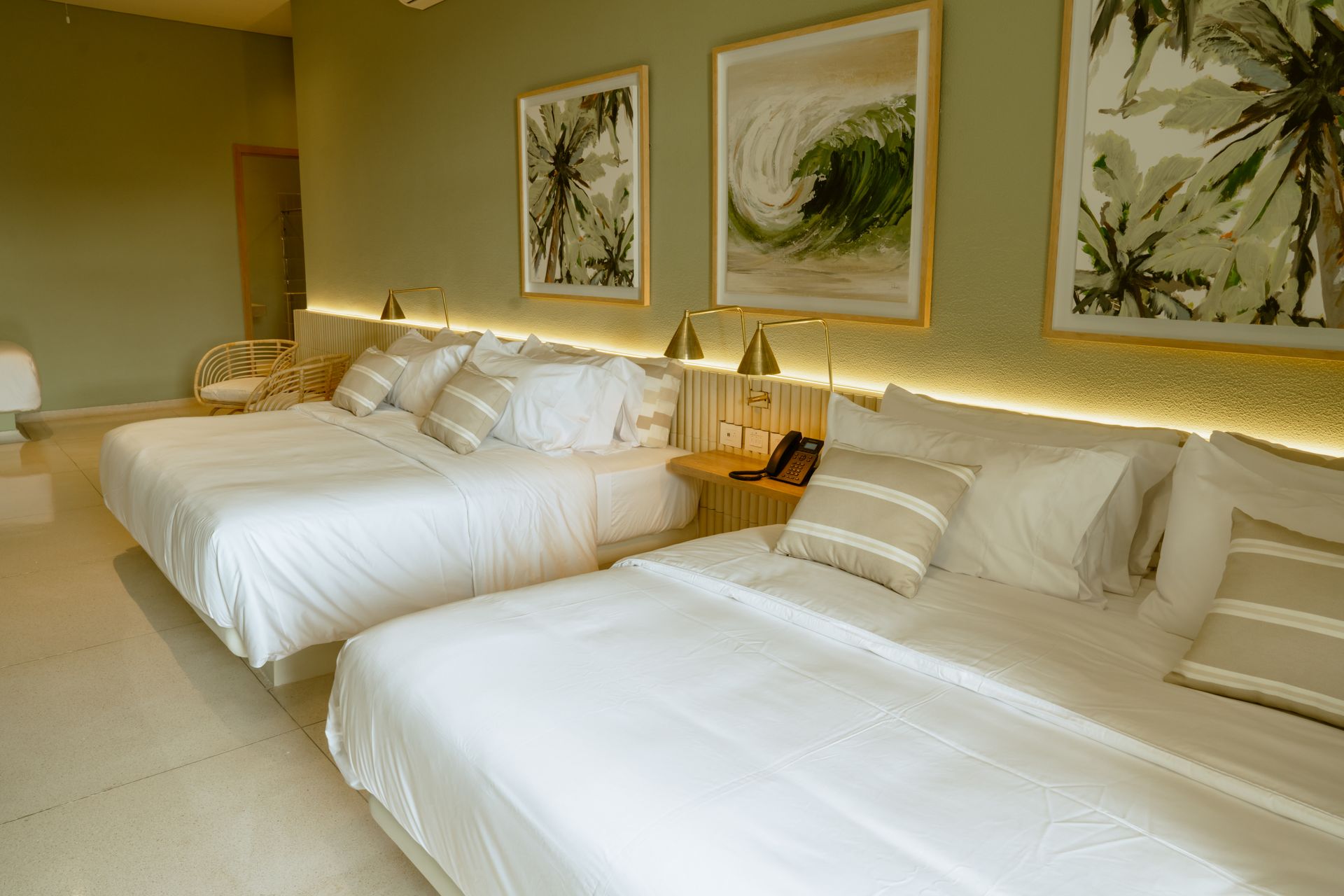 Una habitación de hotel con dos camas y dos cuadros en la pared.